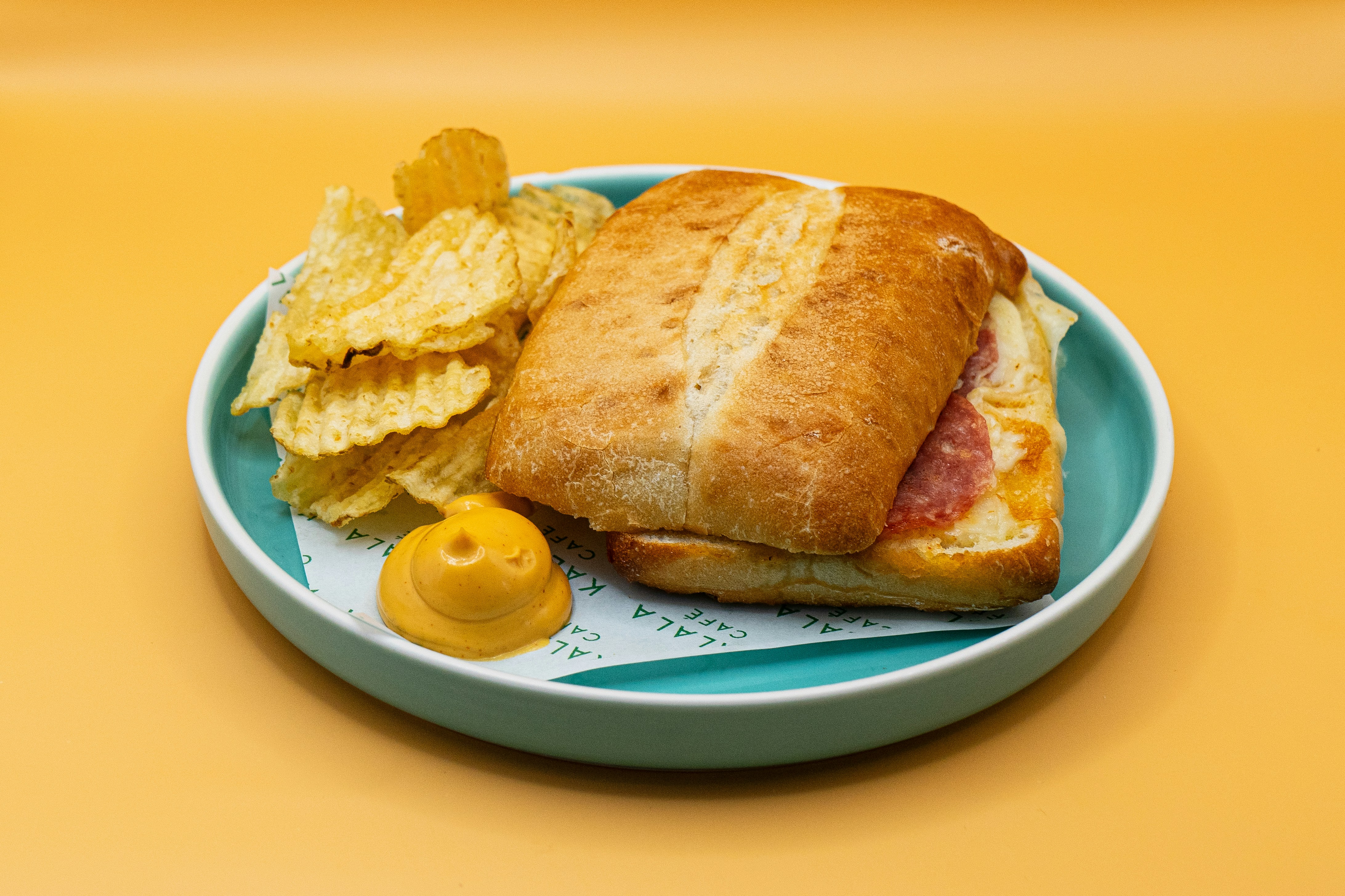 Sandwich and chips on a teal plate