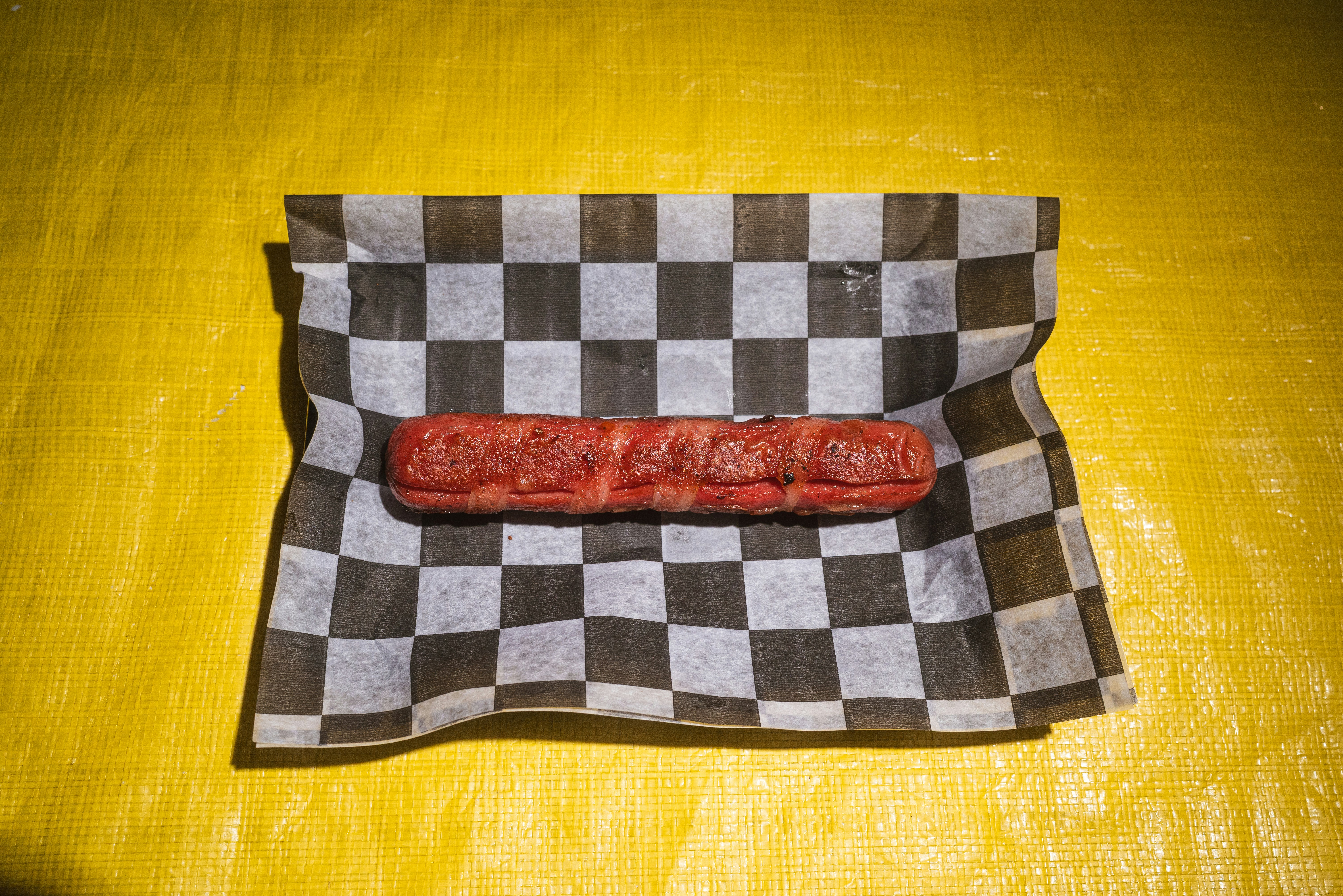 A hot dog on a checkered paper wrapper