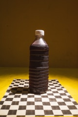 A plastic bottle sitting on top of a chess board