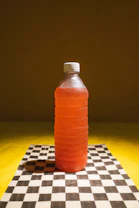 A plastic bottle sitting on top of a checkered table