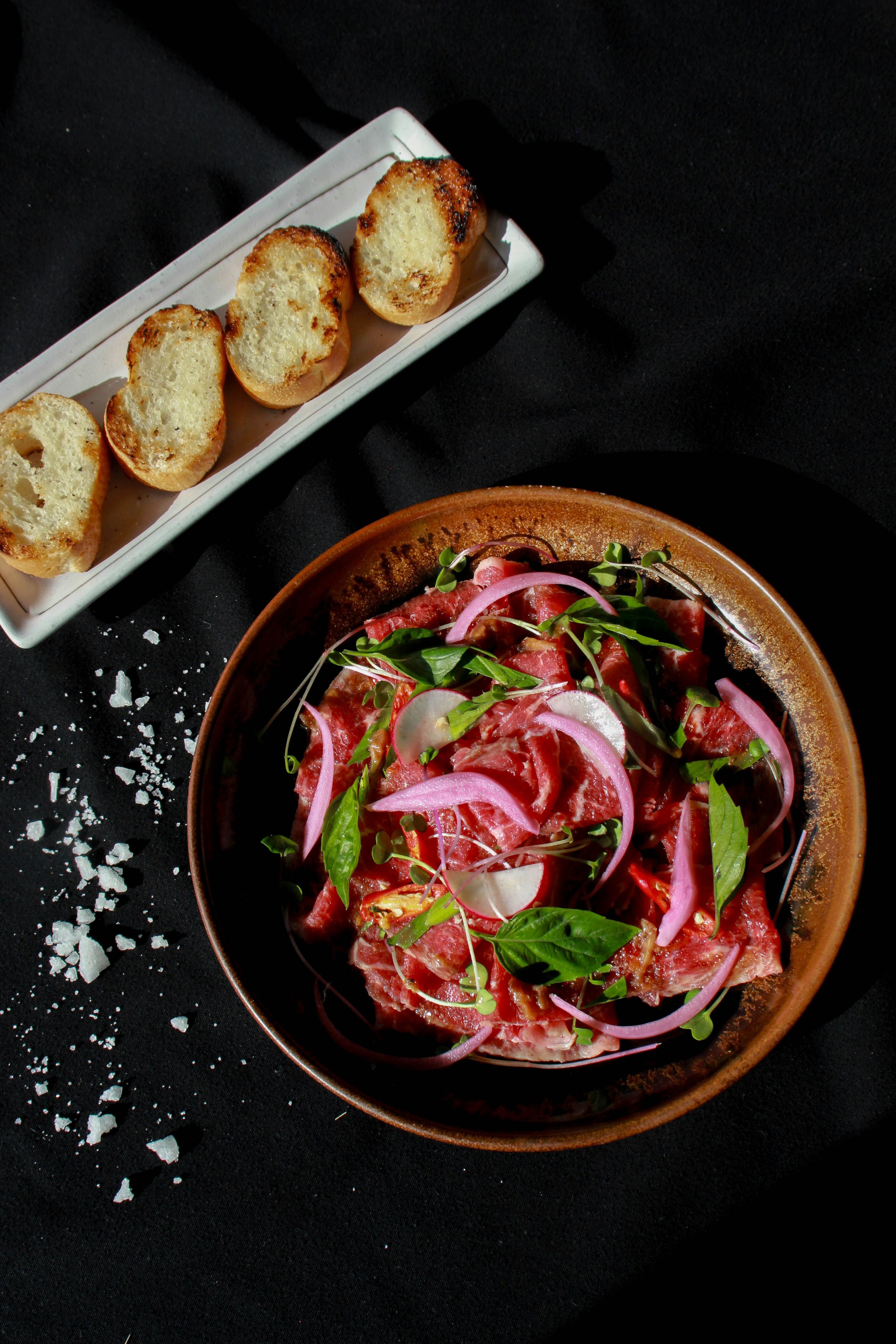 Un bol de salade à côté d’une assiette de pain