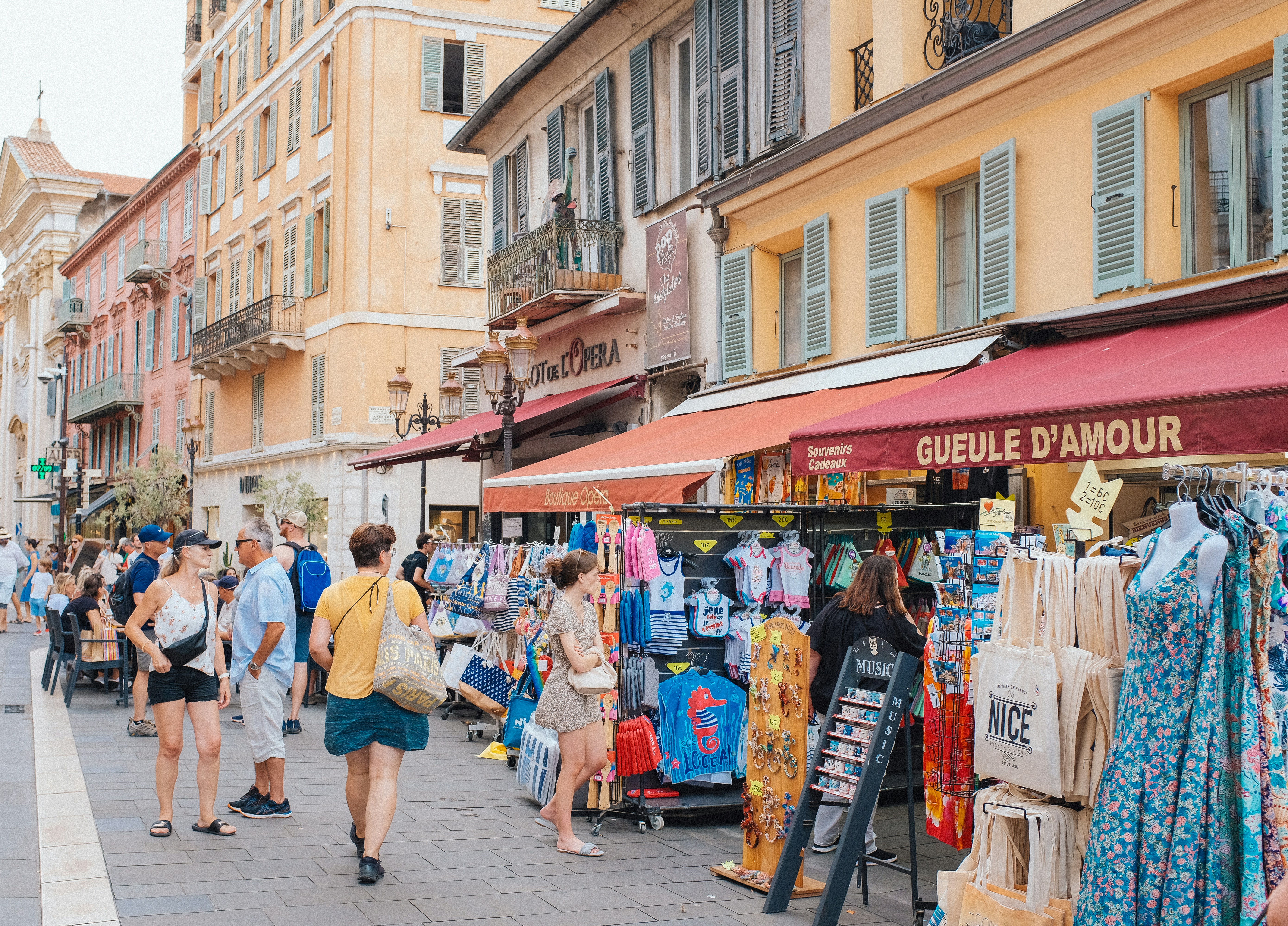 A group of people walking down a street next to shops