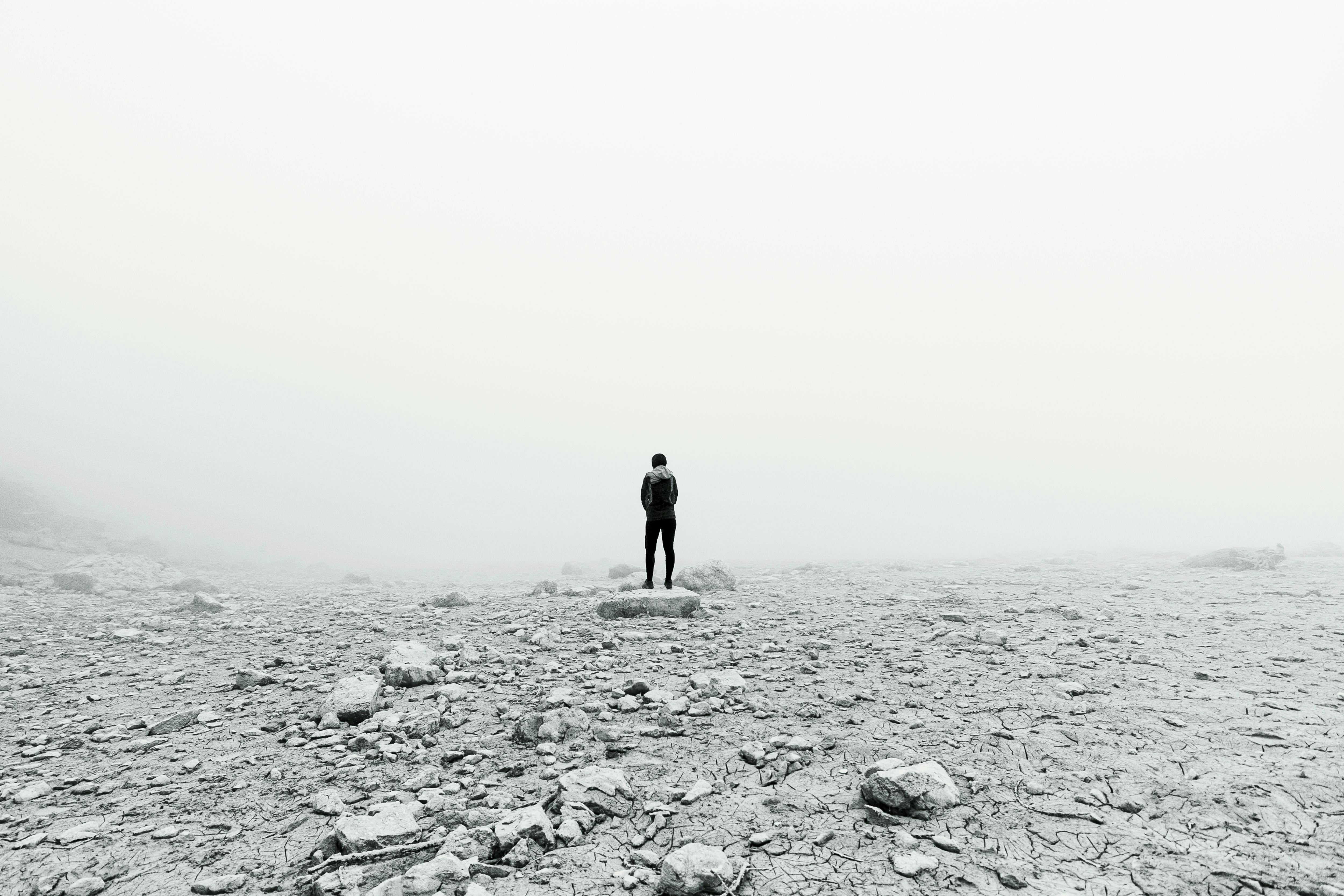 A man standing on top of a rocky field