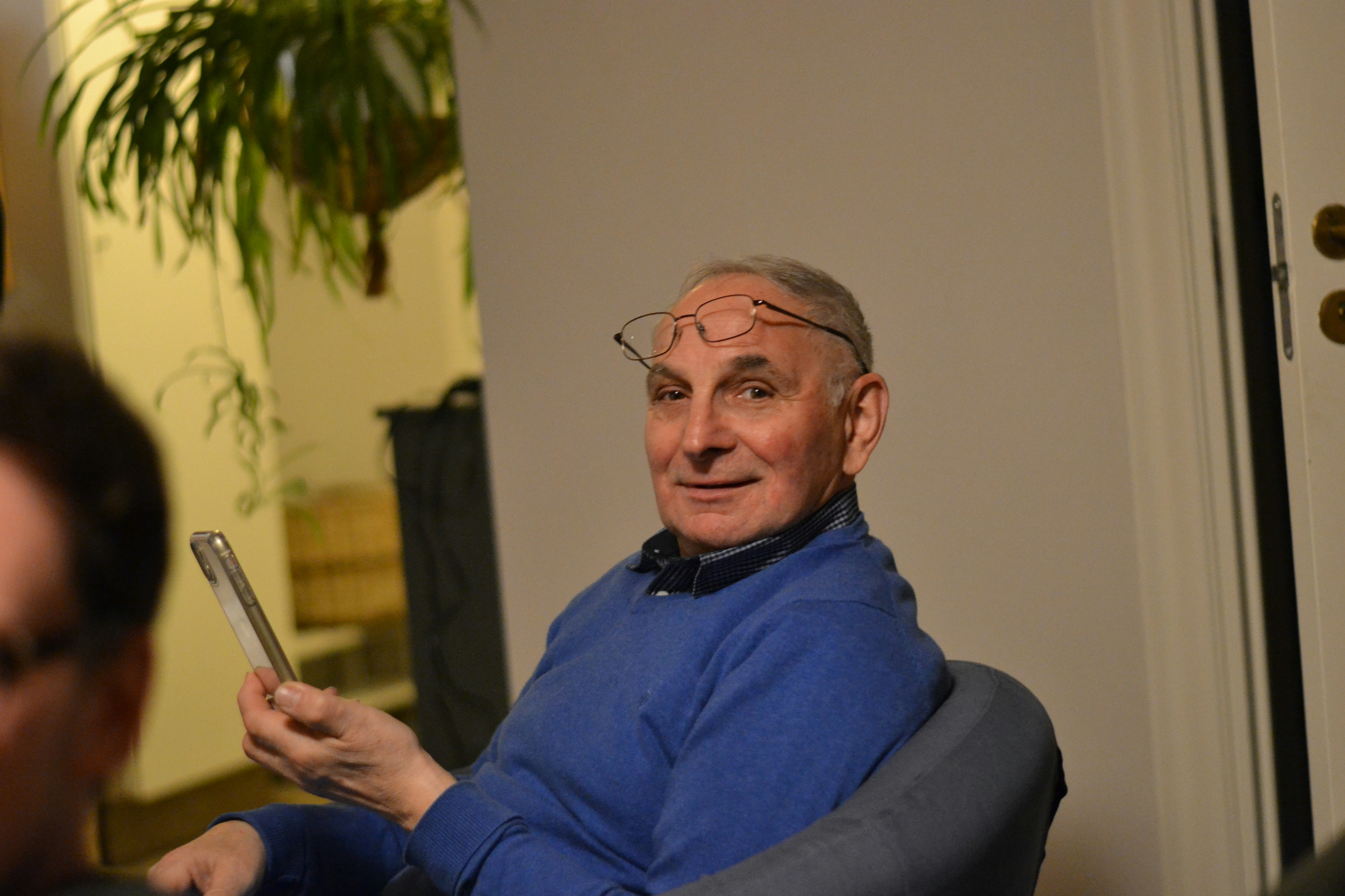 A man sitting in a chair holding a cell phone