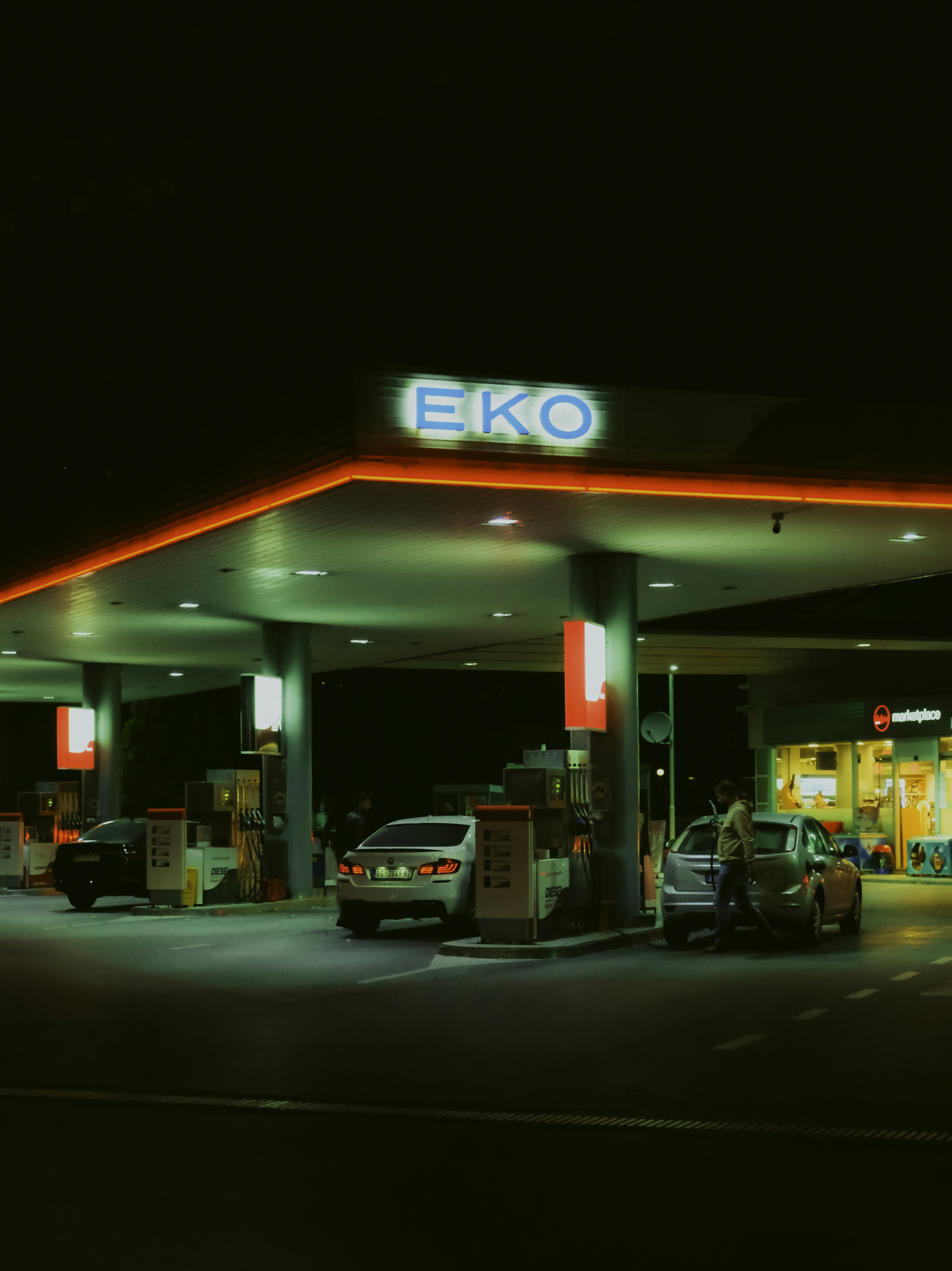 Sebuah pompa bensin menyala di malam hari dengan lampu neon
