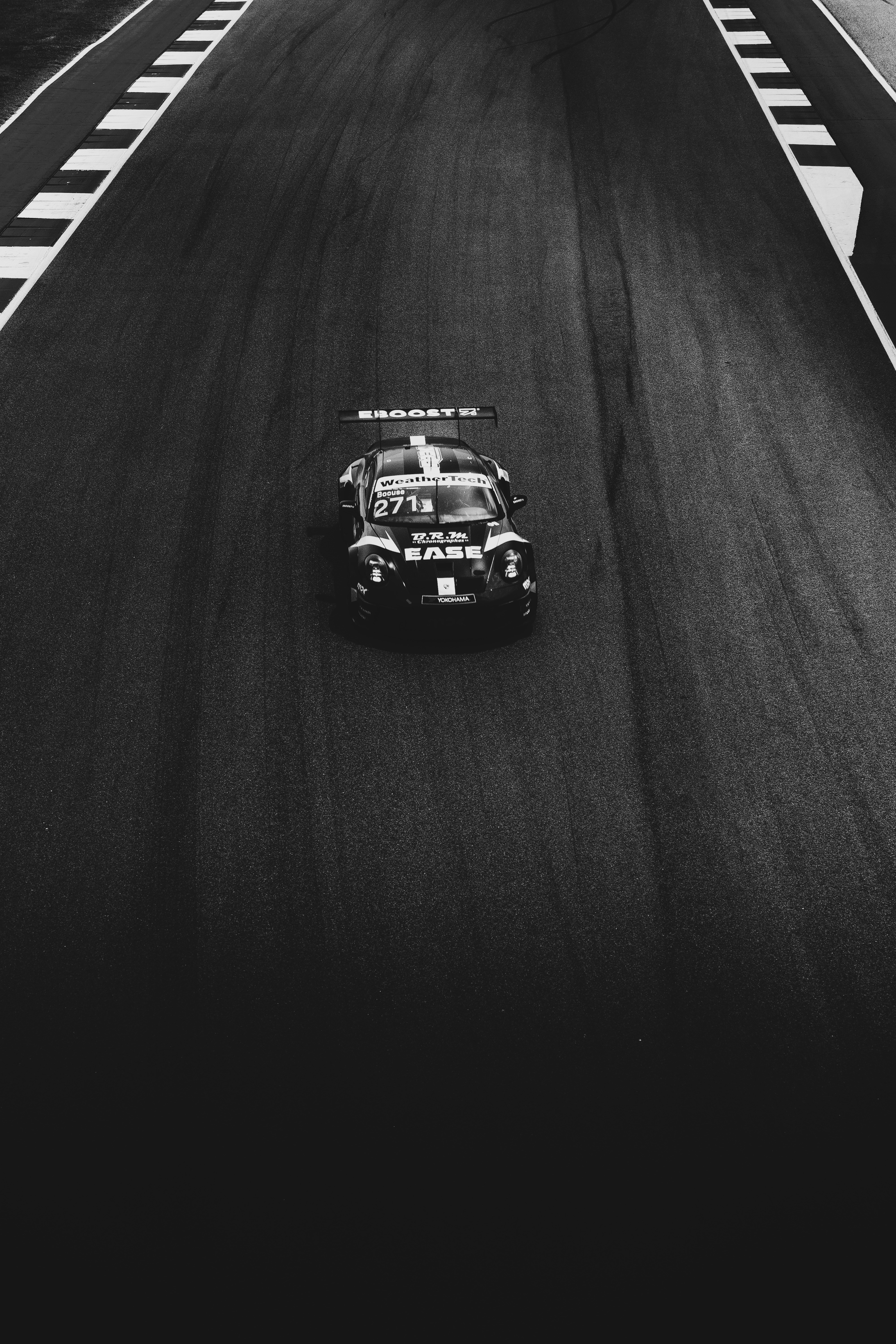 A black and white photo of a car on a race track