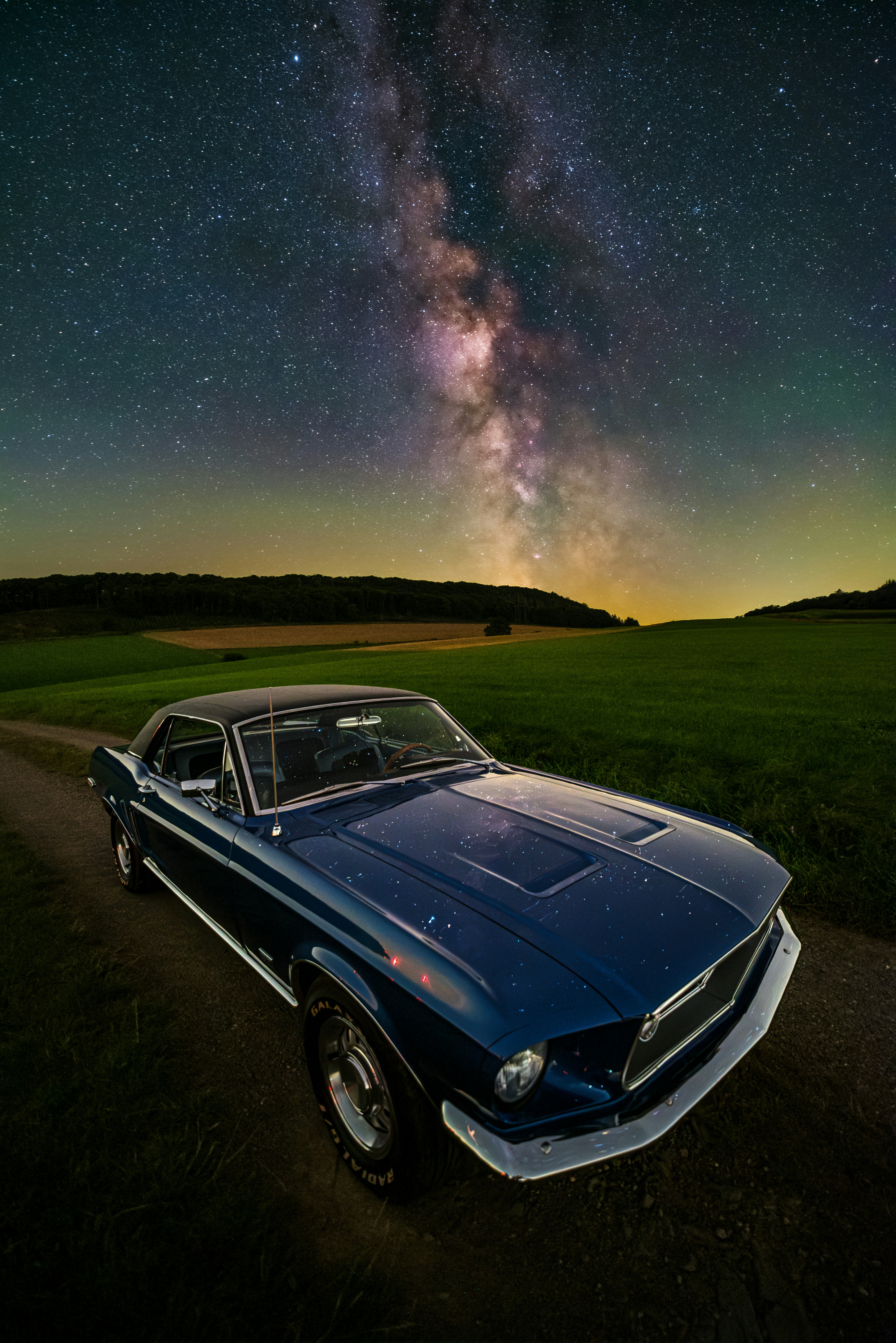 A car parked on a dirt road under a night sky filled with stars photo ...