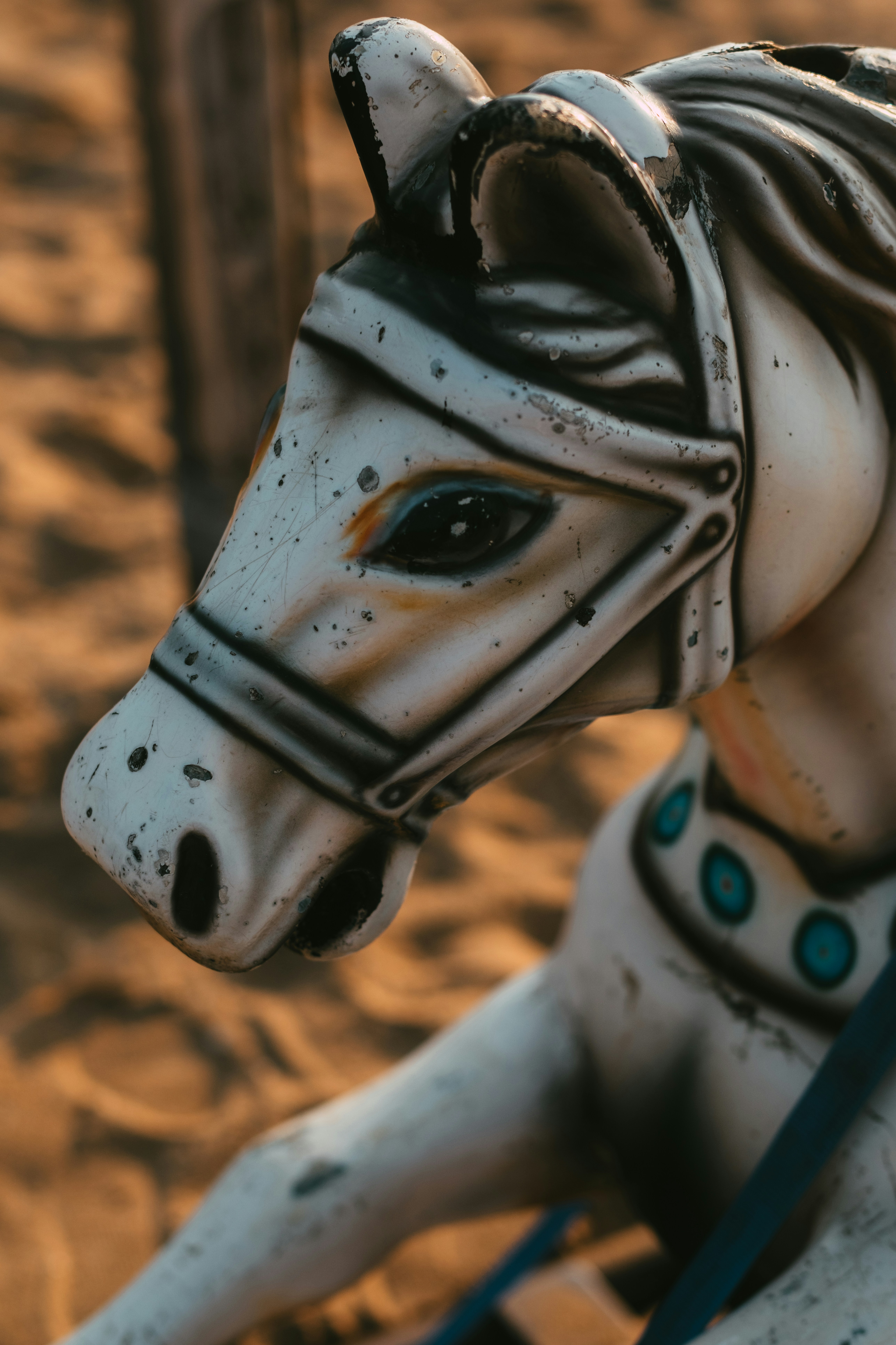 Eine Statue eines weißen Pferdes, die auf einem sandigen Boden sitzt