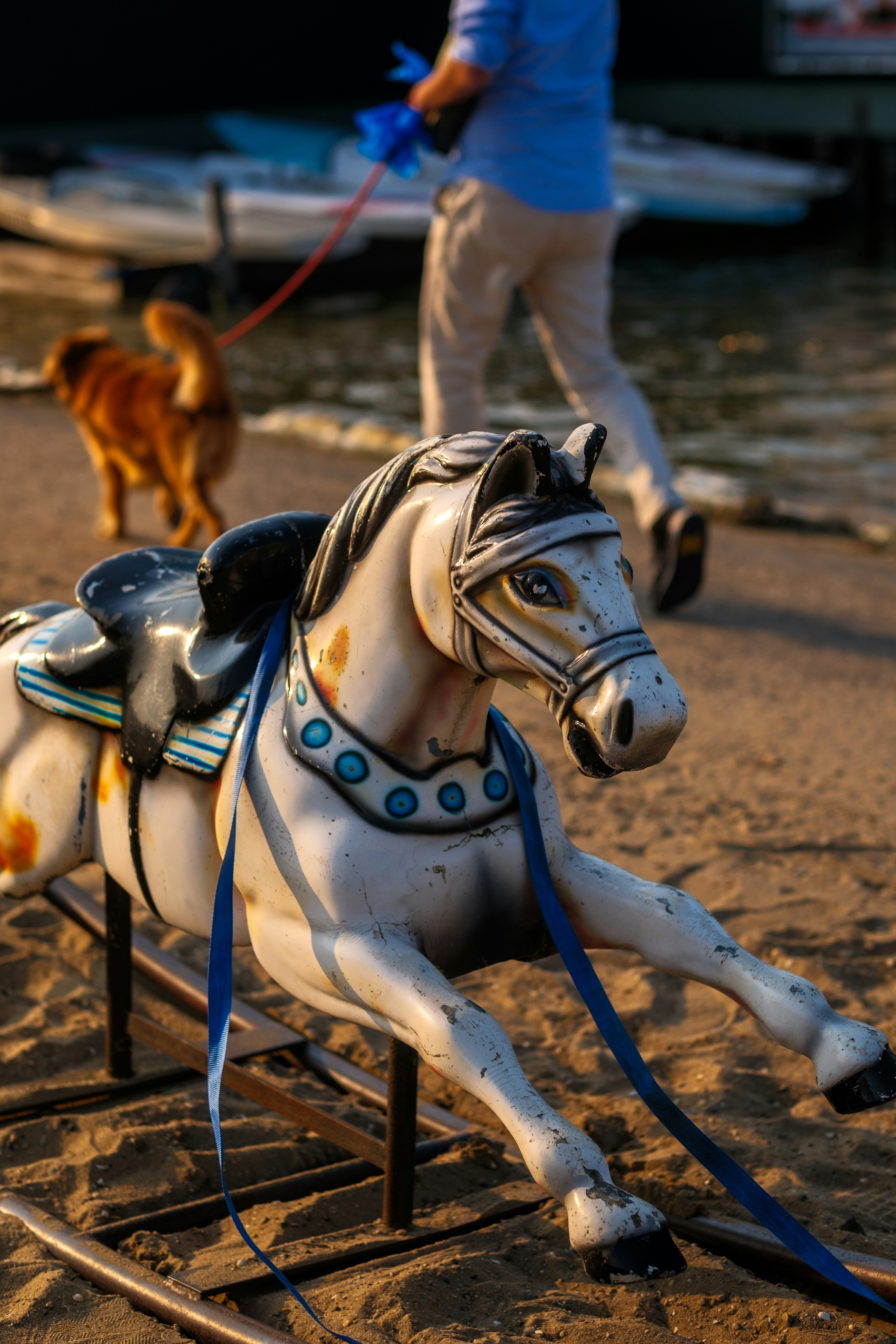 Um cavalo de brinquedo puxando um cachorro na coleira