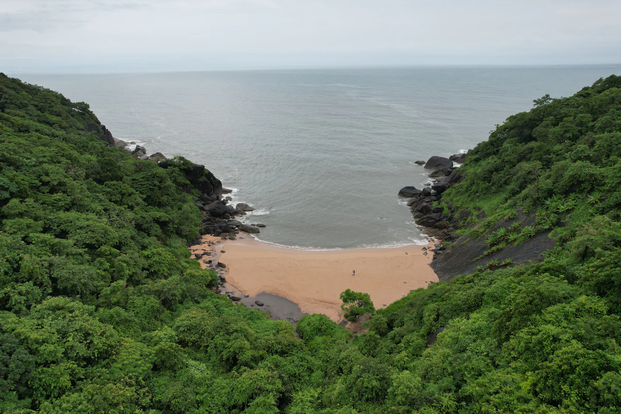 A secluded cove hemmed in by green cliffs in South Goa
