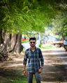 A man standing in the middle of a dirt road