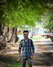 A man standing in the middle of a dirt road