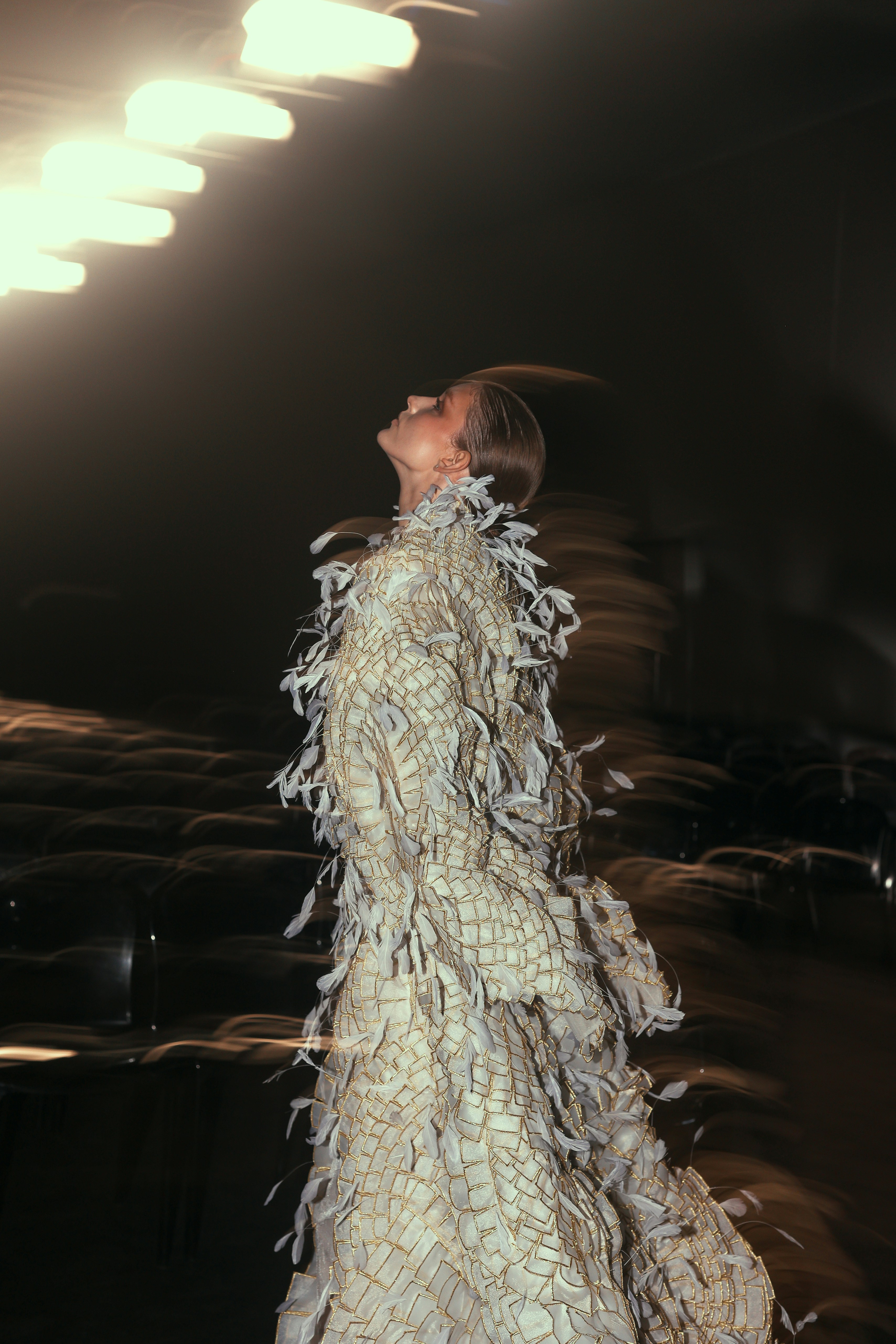 A woman walking down a runway in a white dress