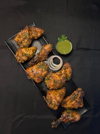 A tray of chicken wings with a side of dipping sauce