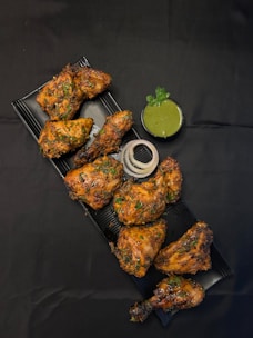 A tray of chicken wings with a side of dipping sauce