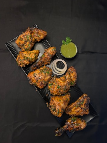A tray of chicken wings with a side of dipping sauce