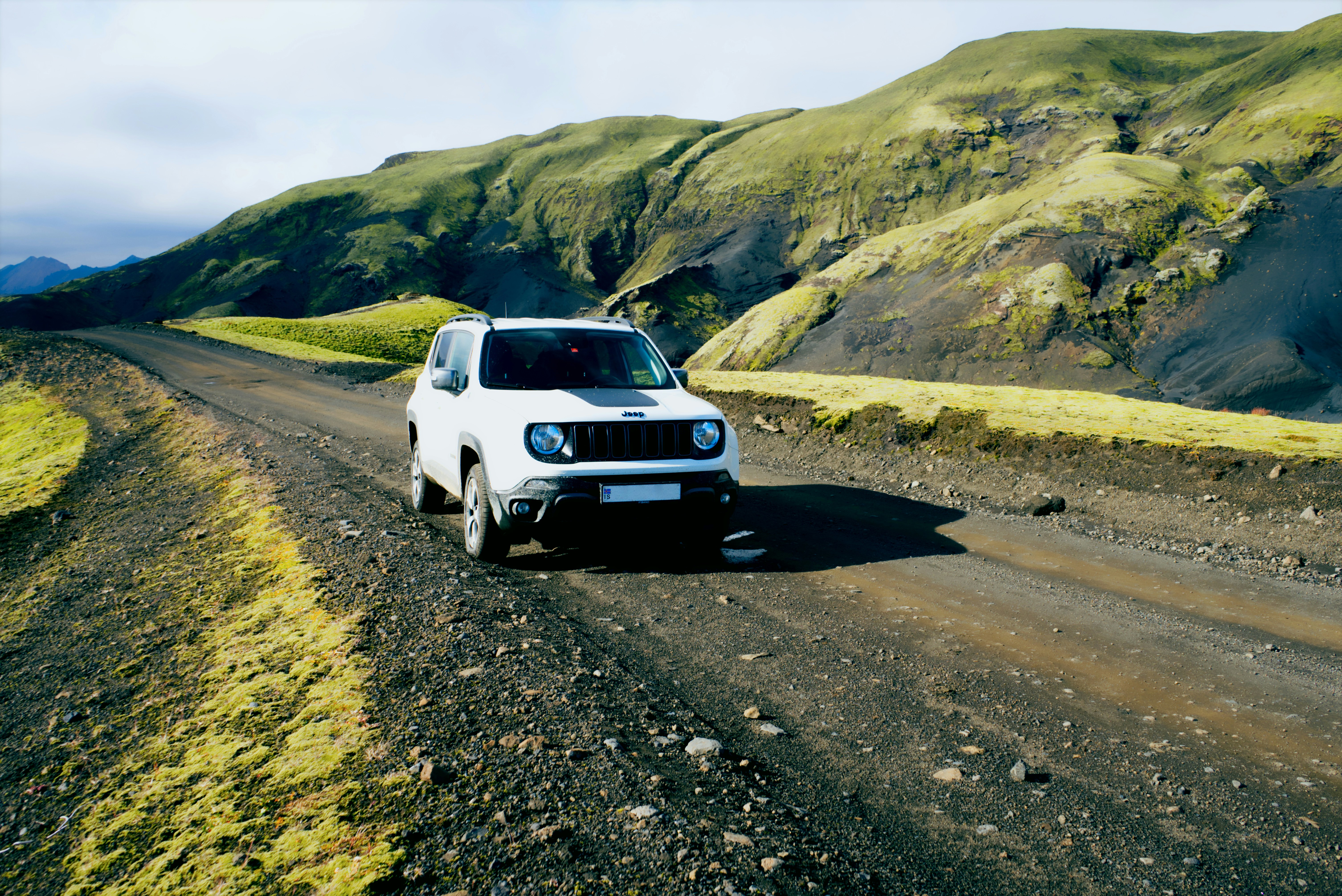 A white truck driving down a dirt road