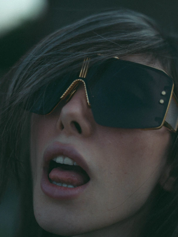 A woman wearing a pair of sunglasses with her mouth open