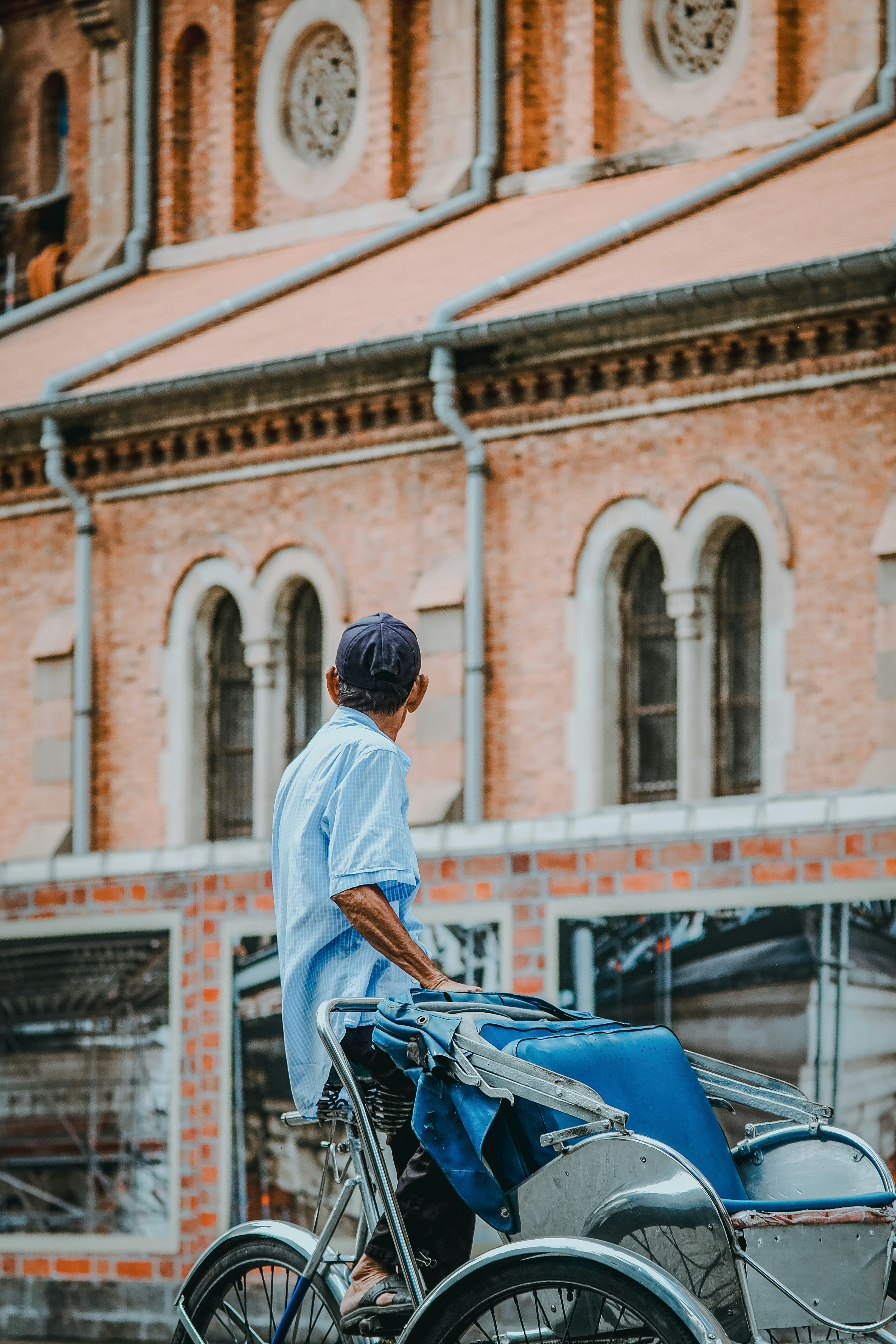 A man standing on top of a bike next to a building