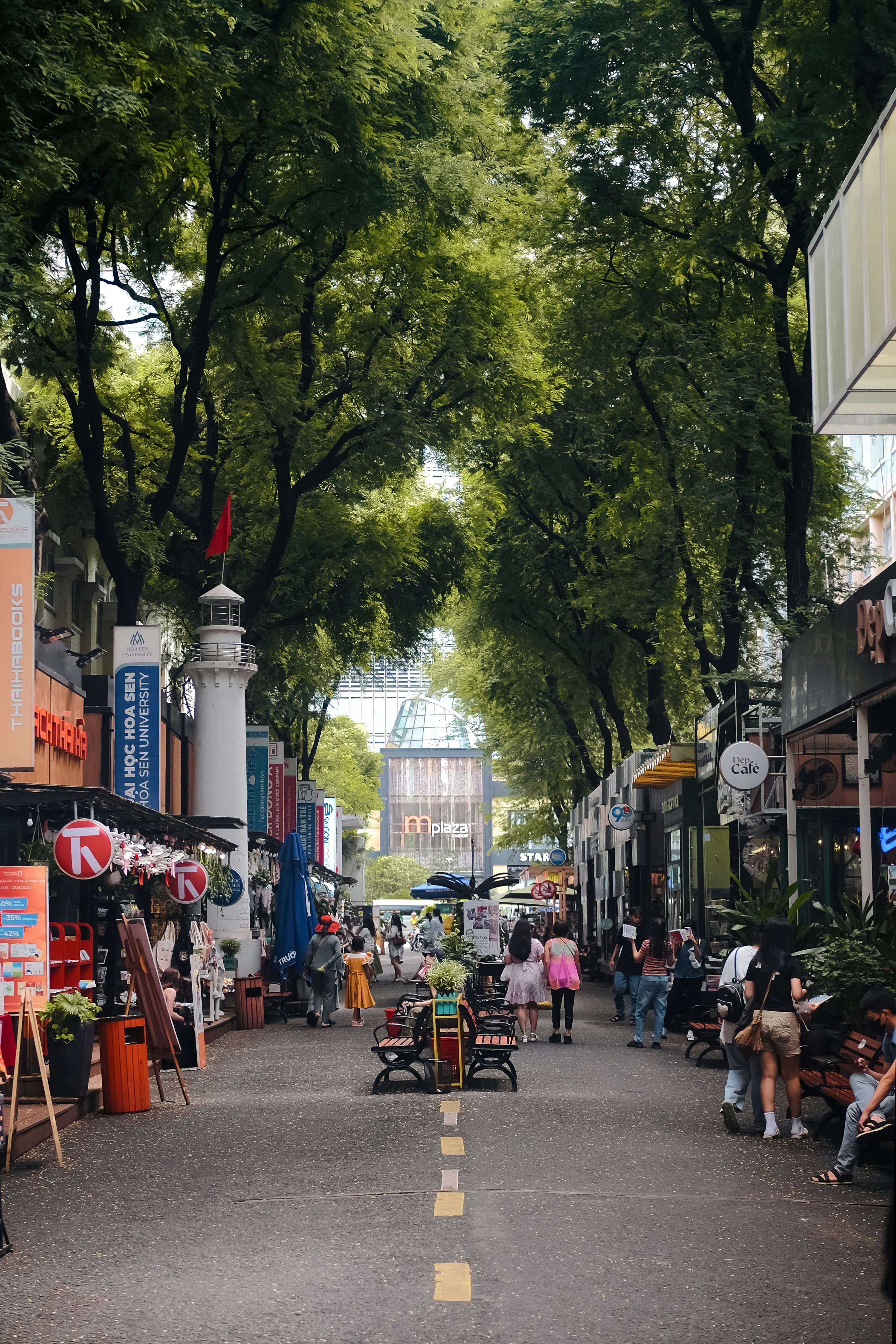 A city street lined with trees and shops