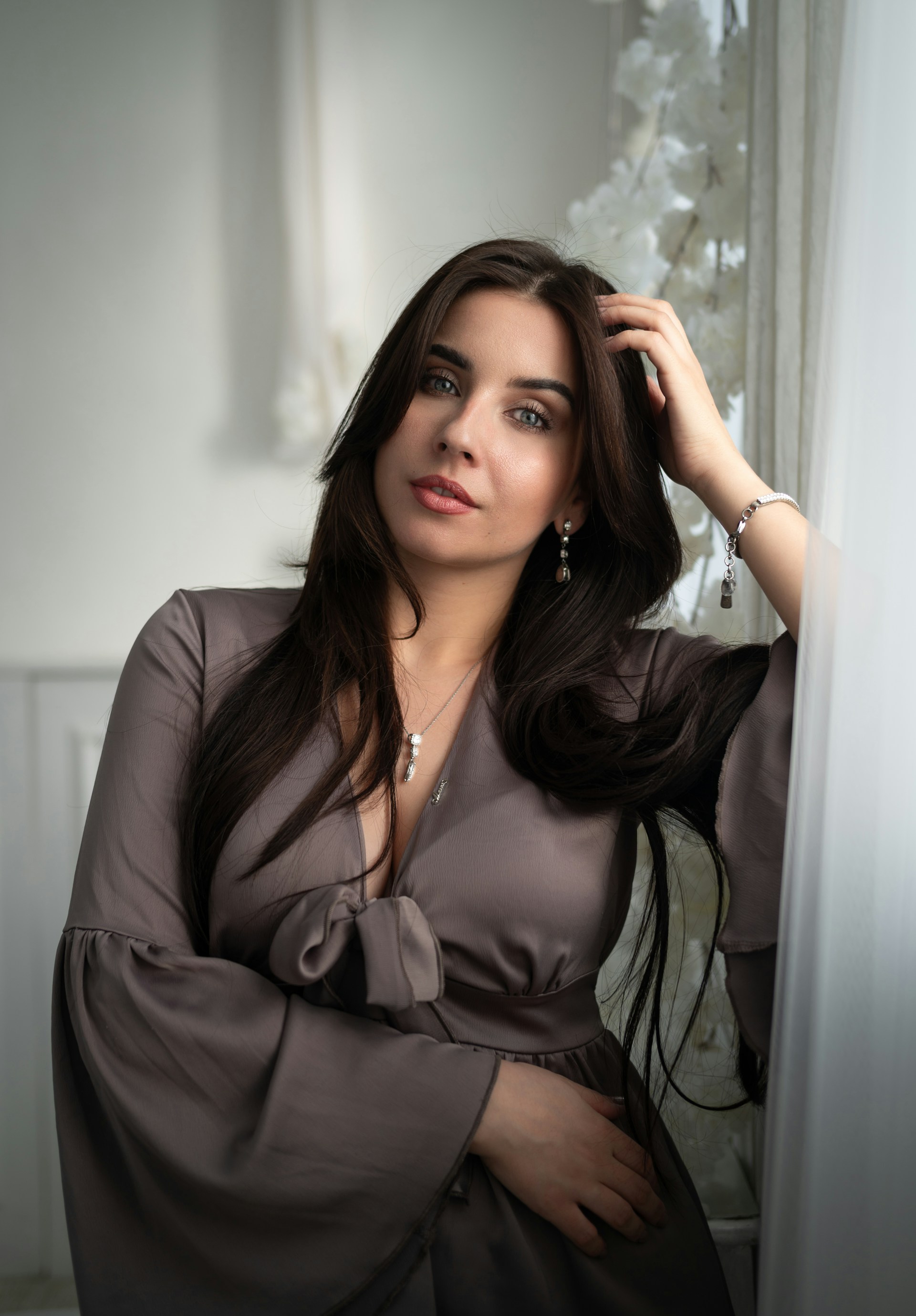 A woman in a dress leaning against a wall