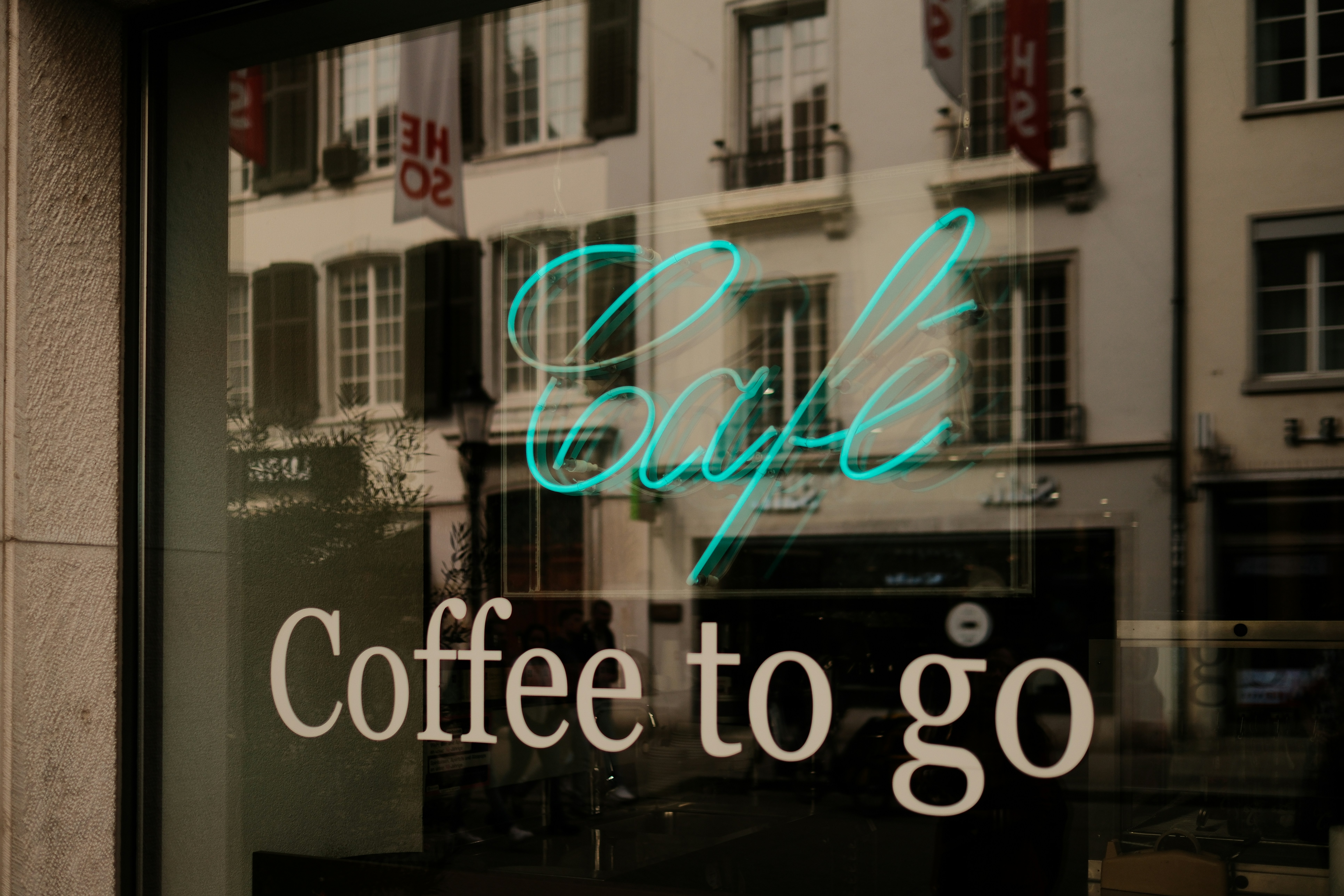 A window with a sign that says coffee to go