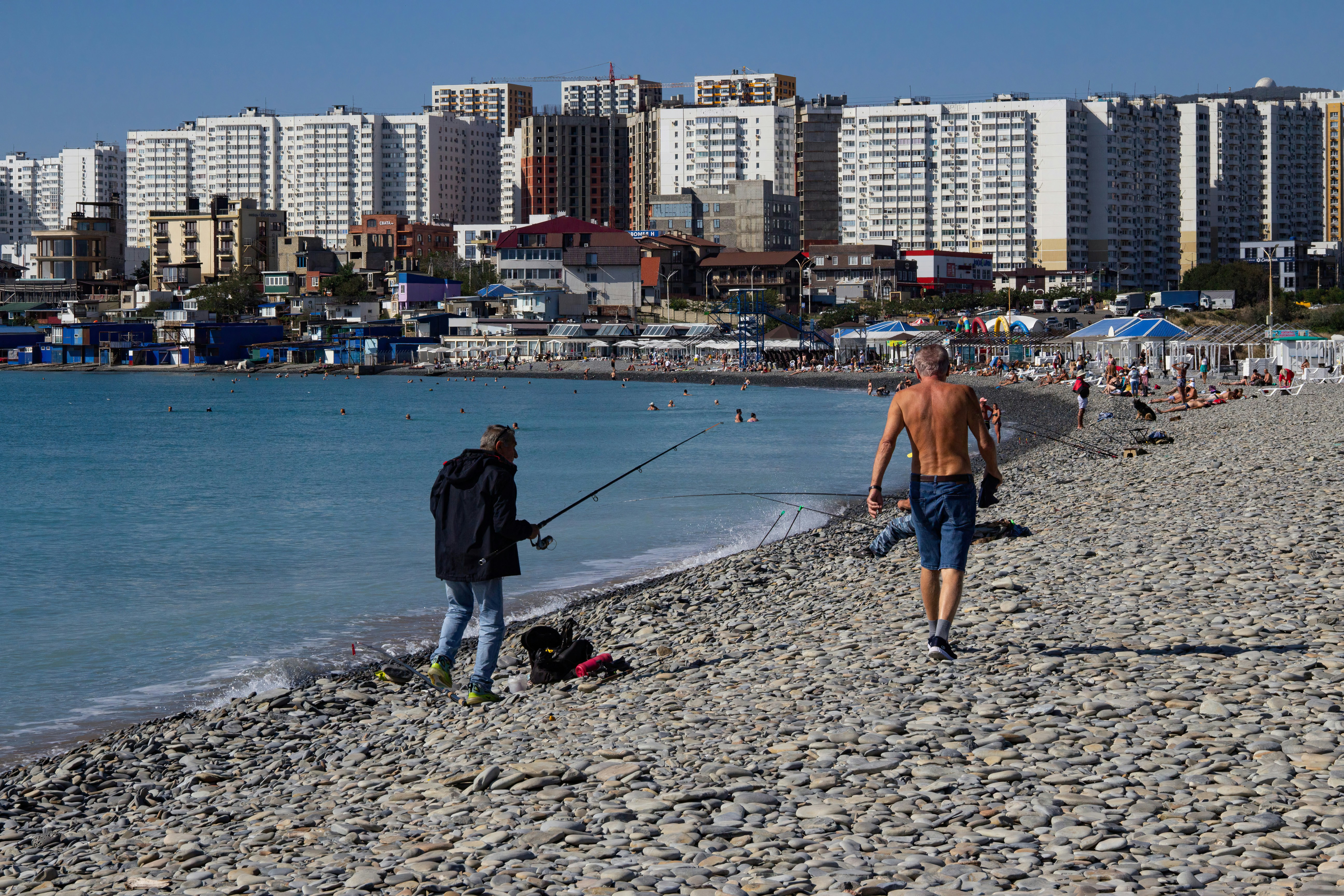 A man and a woman walking along a beach