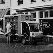 A black and white photo of a man standing next to a truck