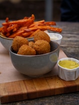 A wooden cutting board topped with bowls of food