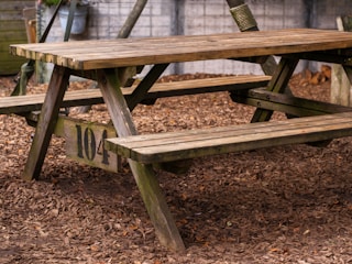 A wooden picnic table sitting in the dirt