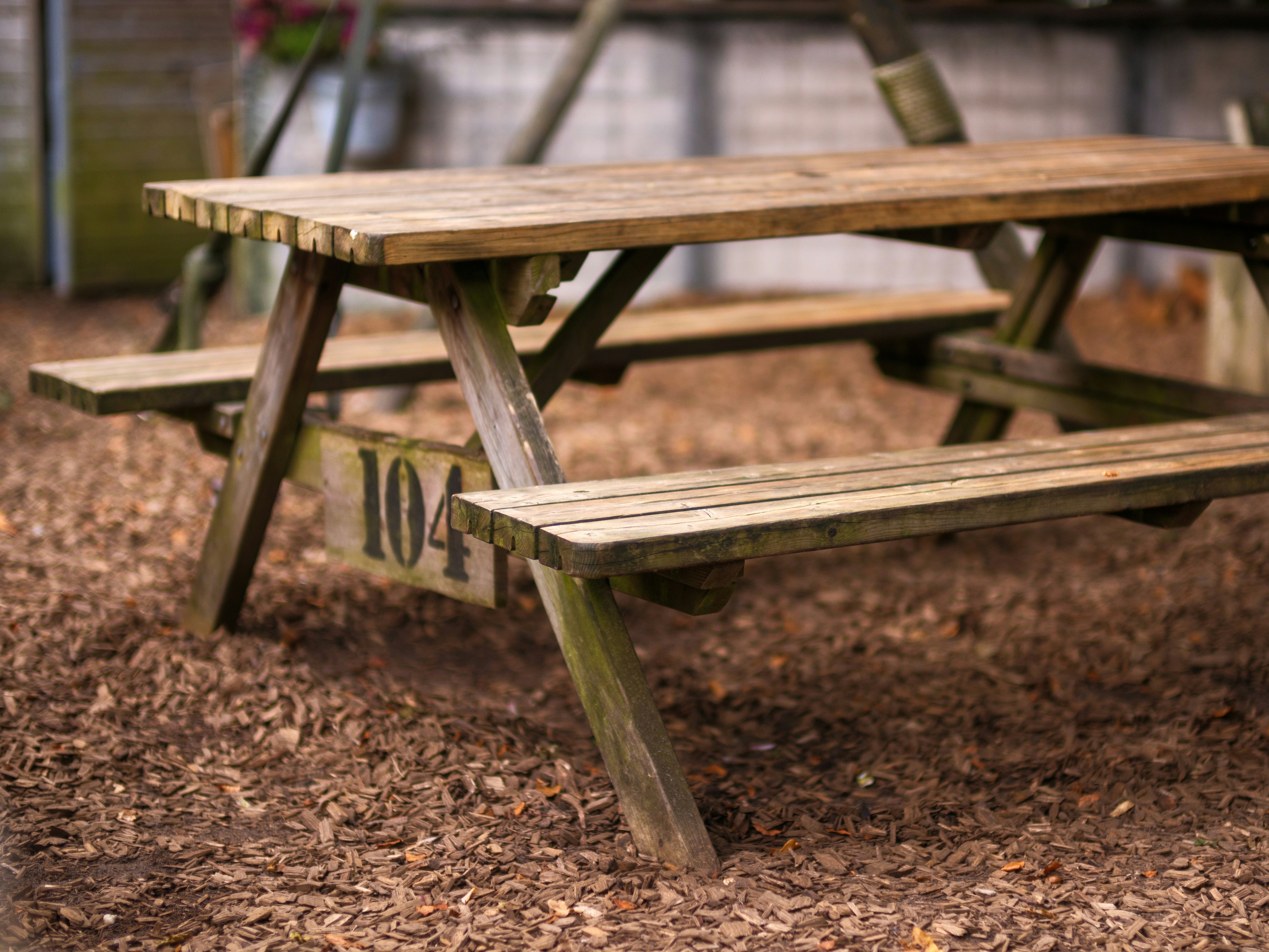 A wooden picnic table sitting in the dirt