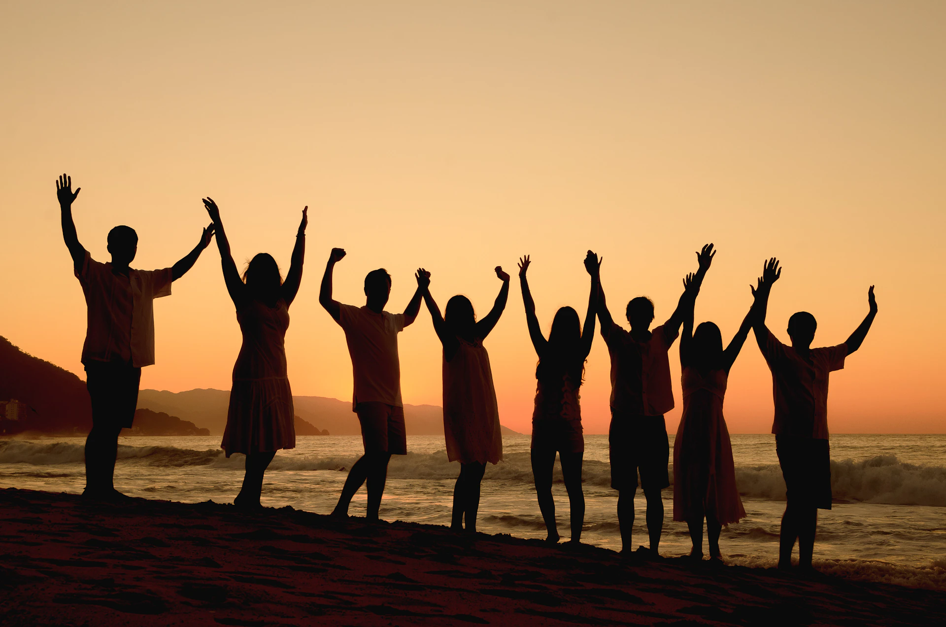A group of people standing on top of a beach