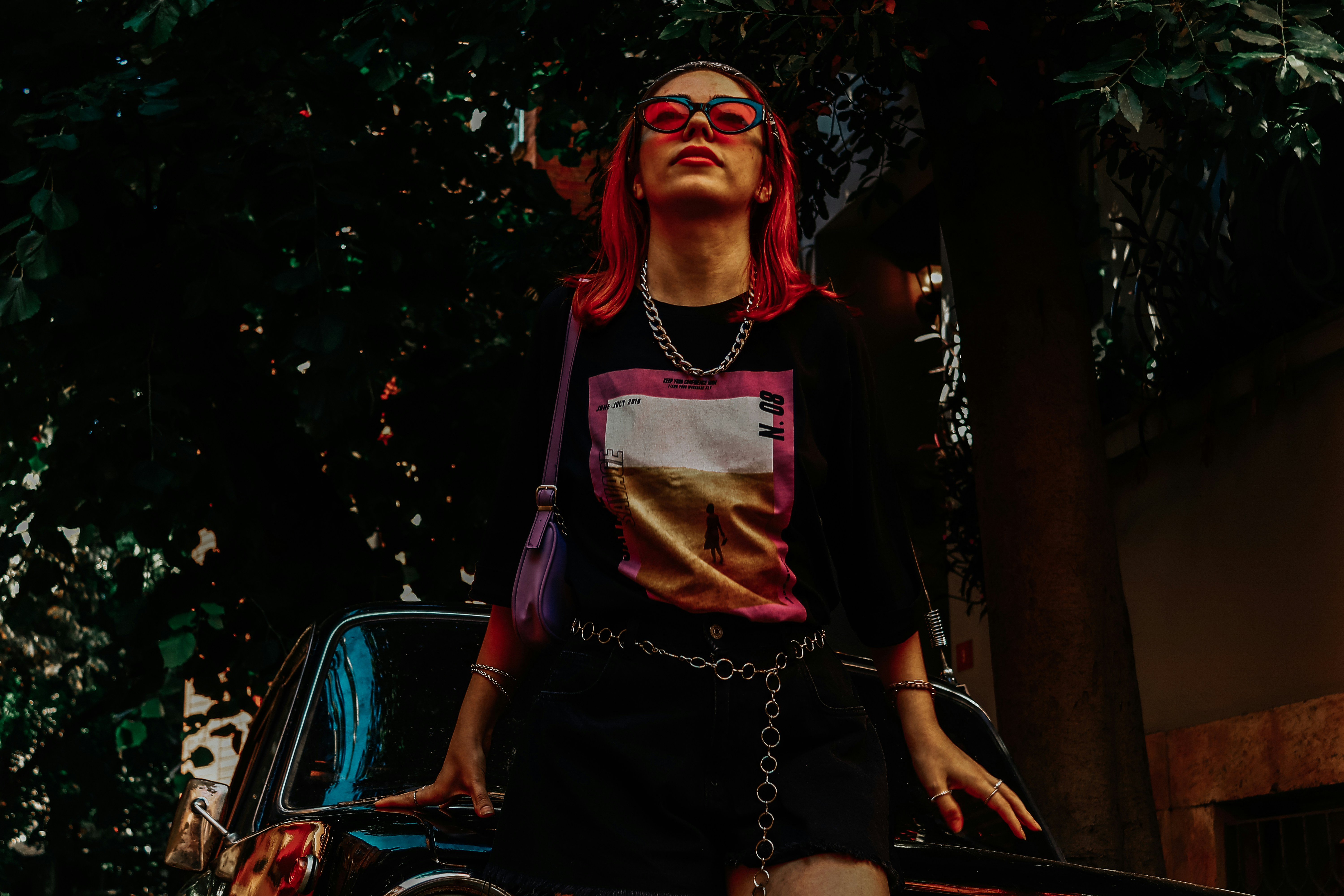 Une femme debout à côté d’une voiture garée