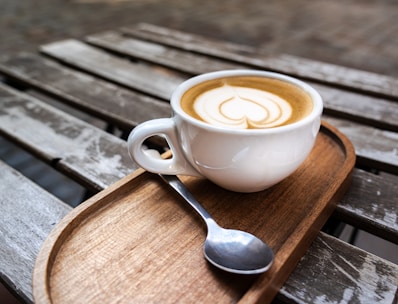 A cup of coffee sitting on top of a wooden tray