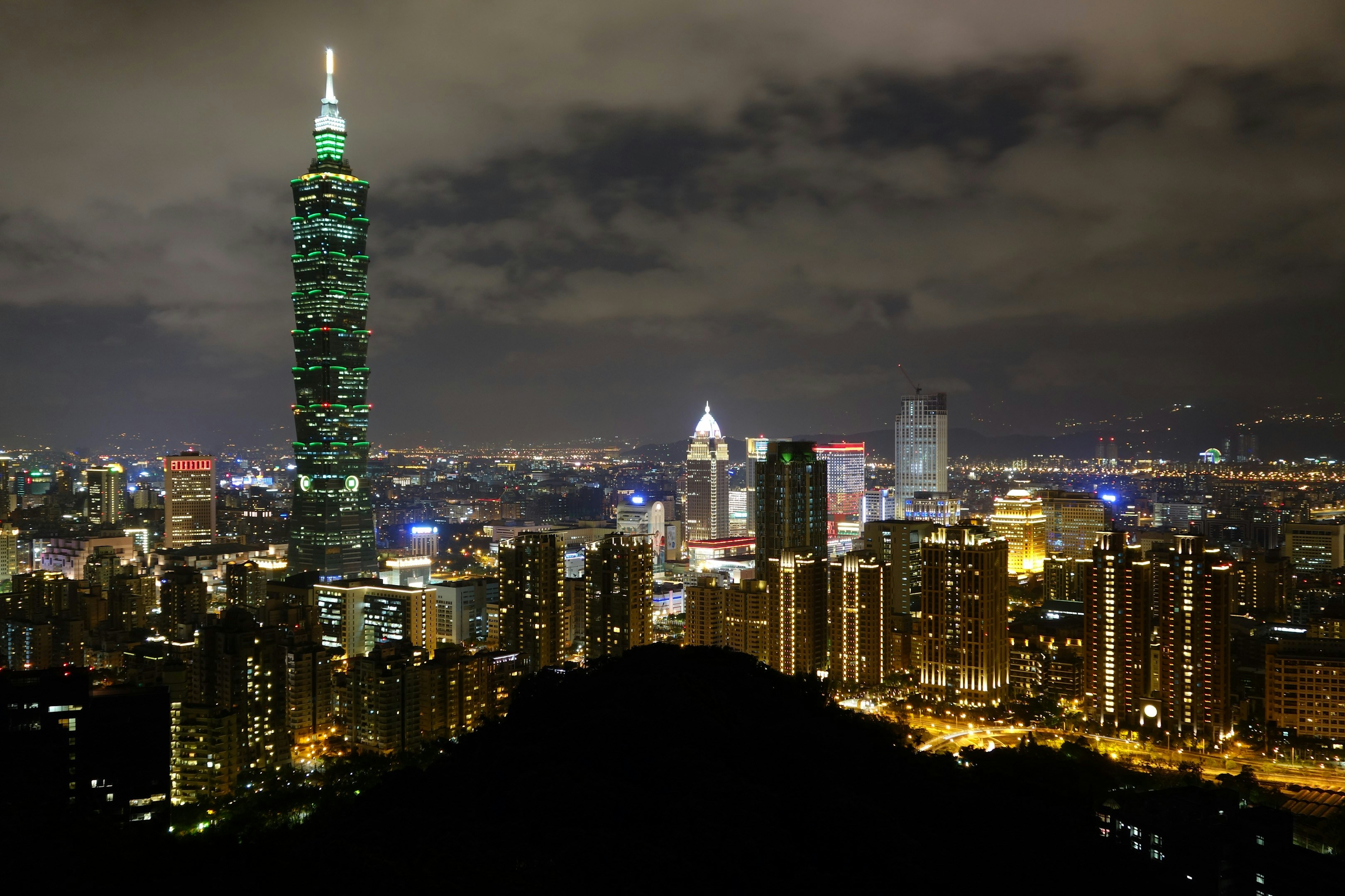 A view of a city at night from the top of a hill