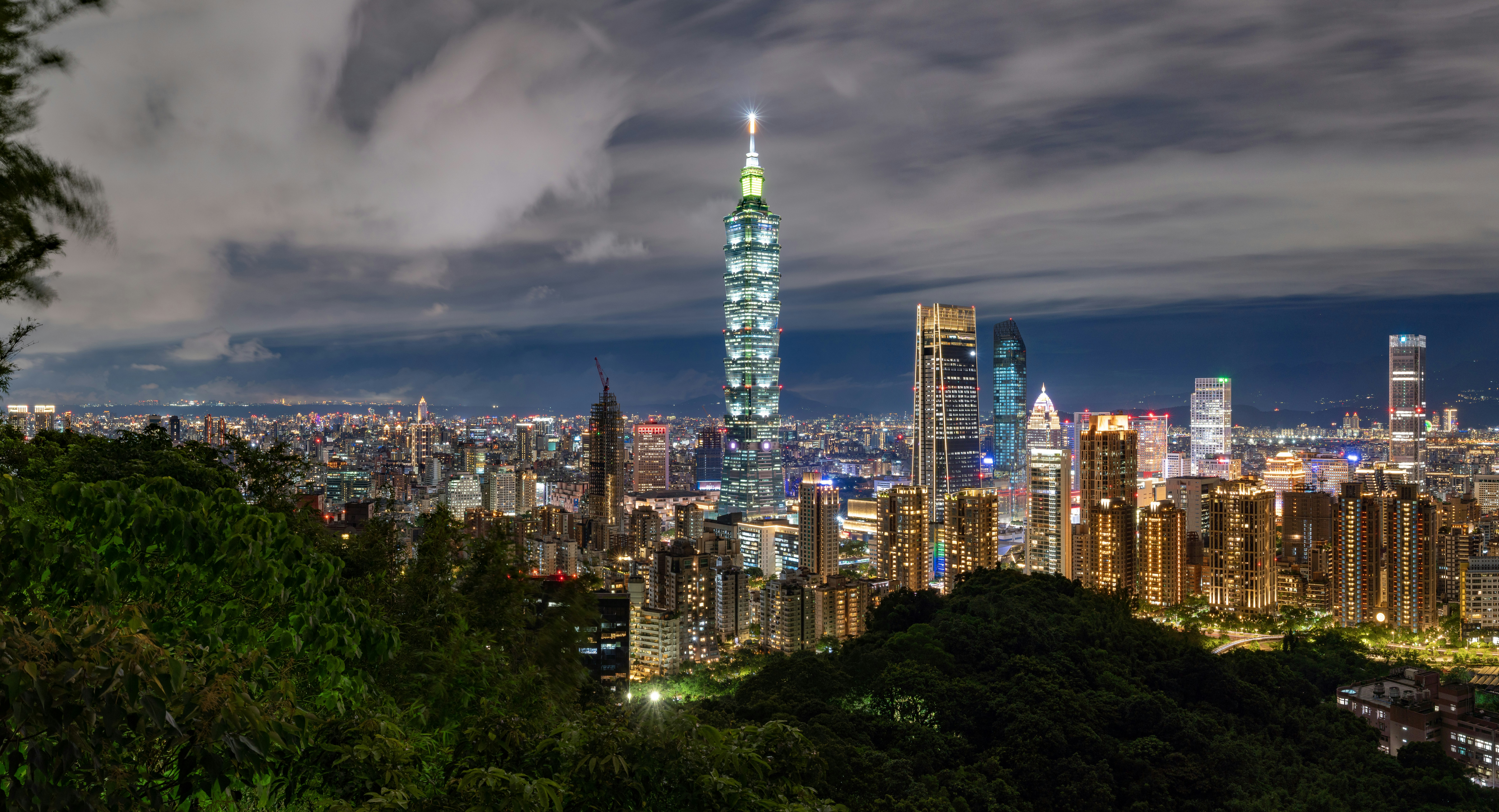 A view of a city at night from the top of a hill