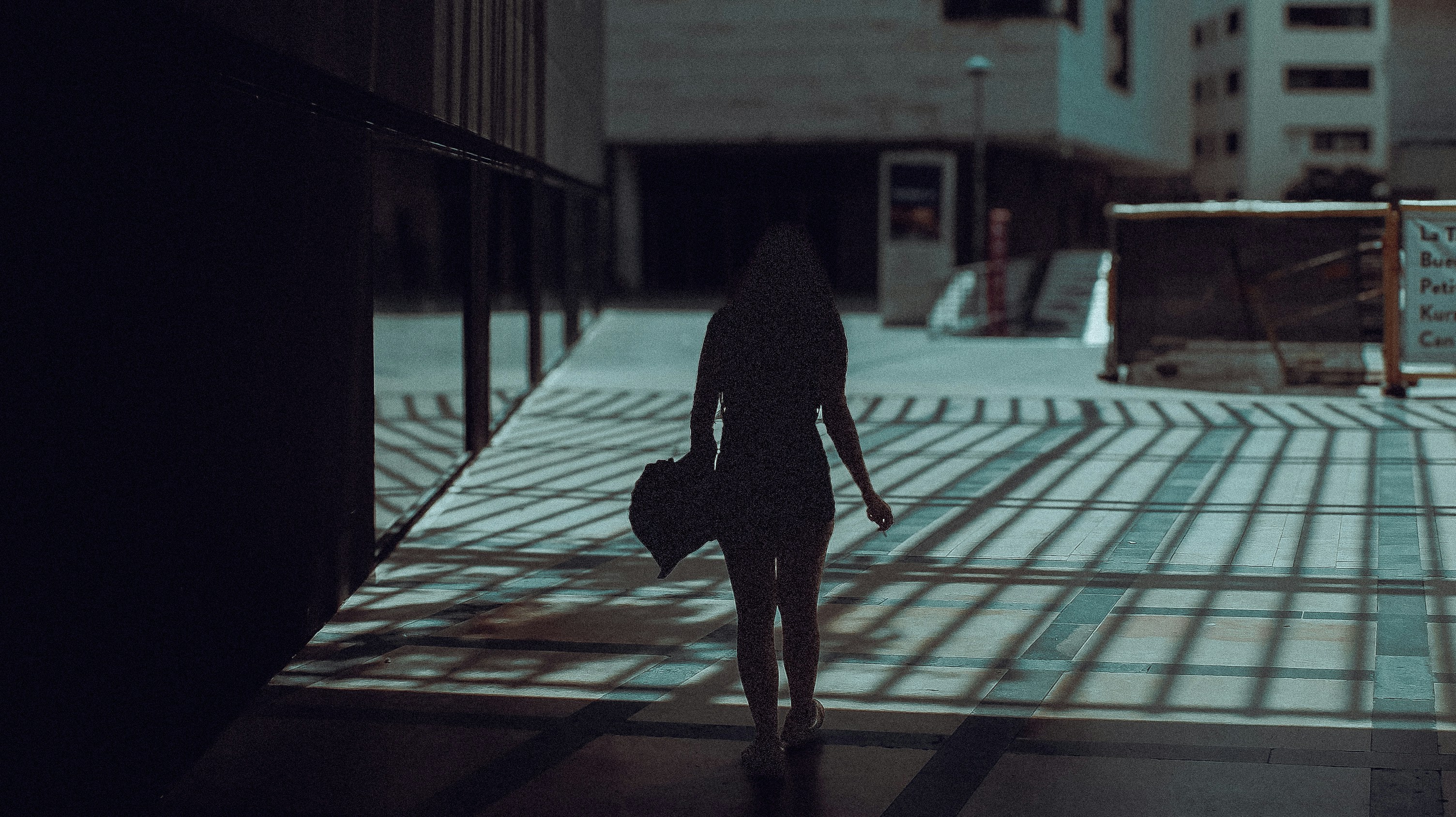 A silhouette of a person walking down a street