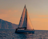 A sailboat sailing in the ocean at sunset
