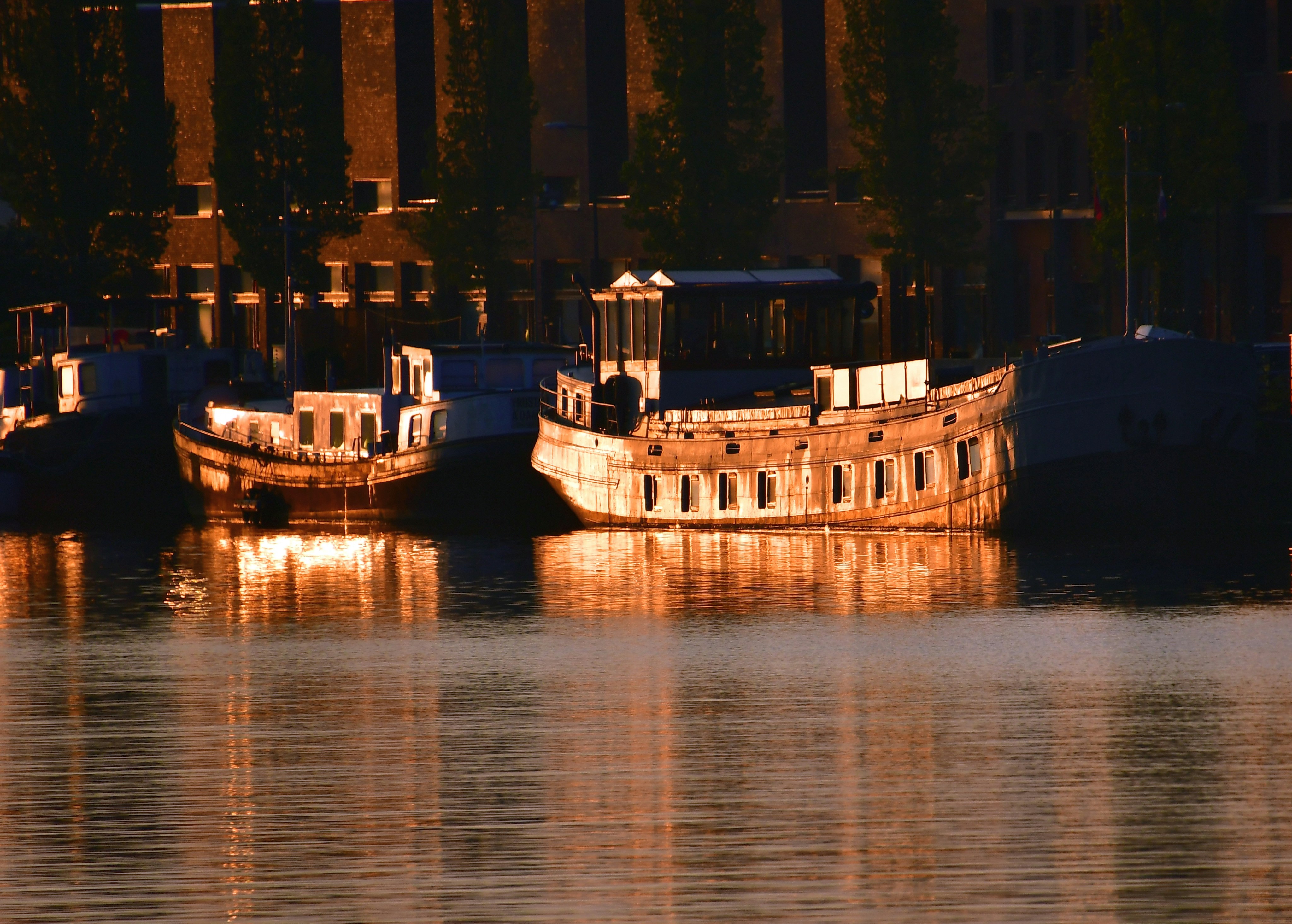Old boats floating on the river lighting up at sunrise