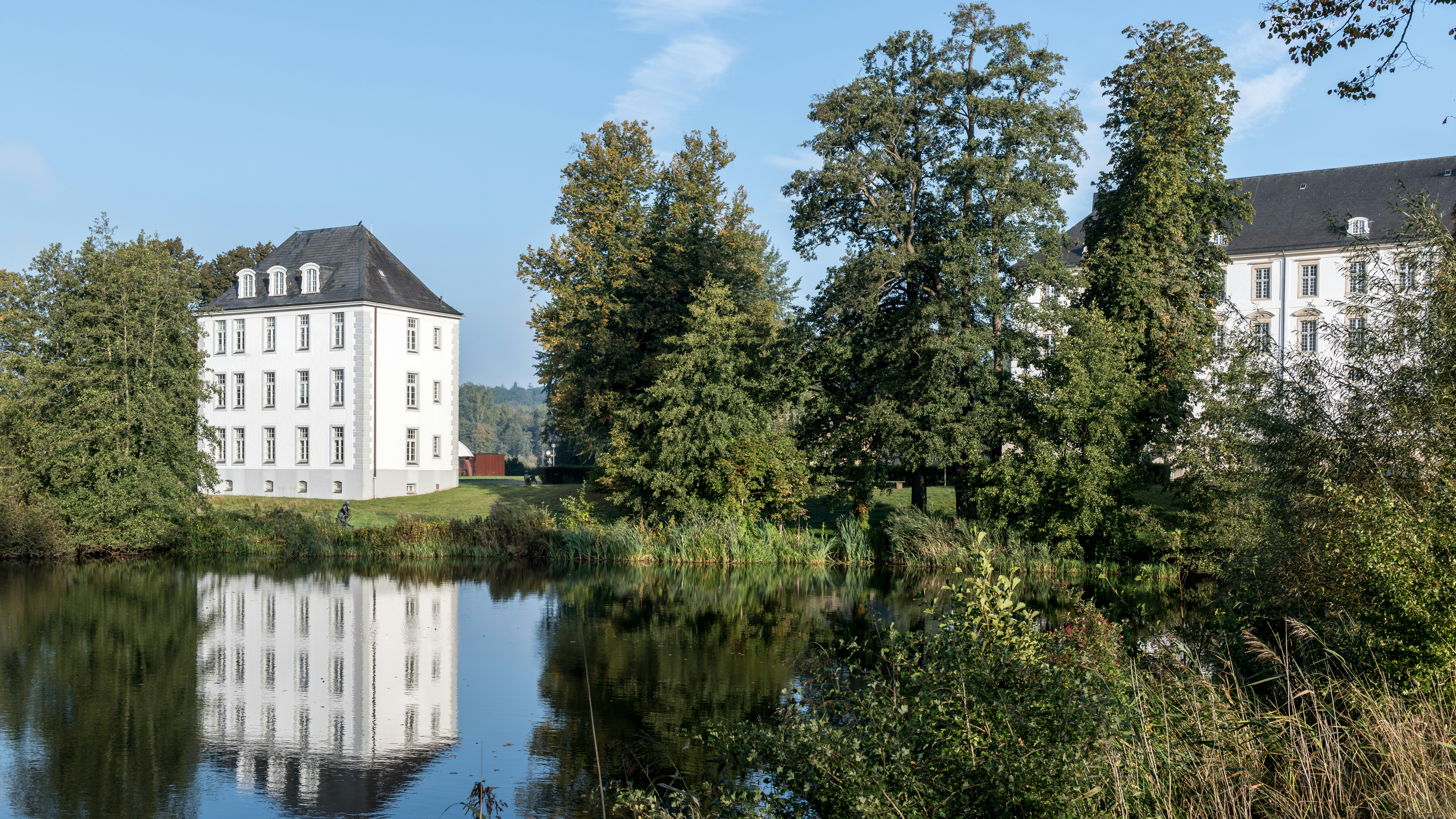 Ein großes weißes Gebäude an einem See