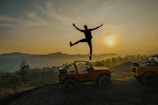 A man jumping off of a jeep into the air