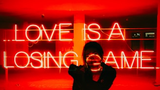 A woman standing in front of a neon sign