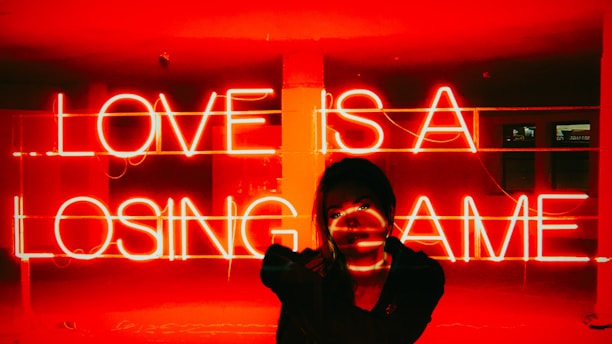 A woman standing in front of a neon sign