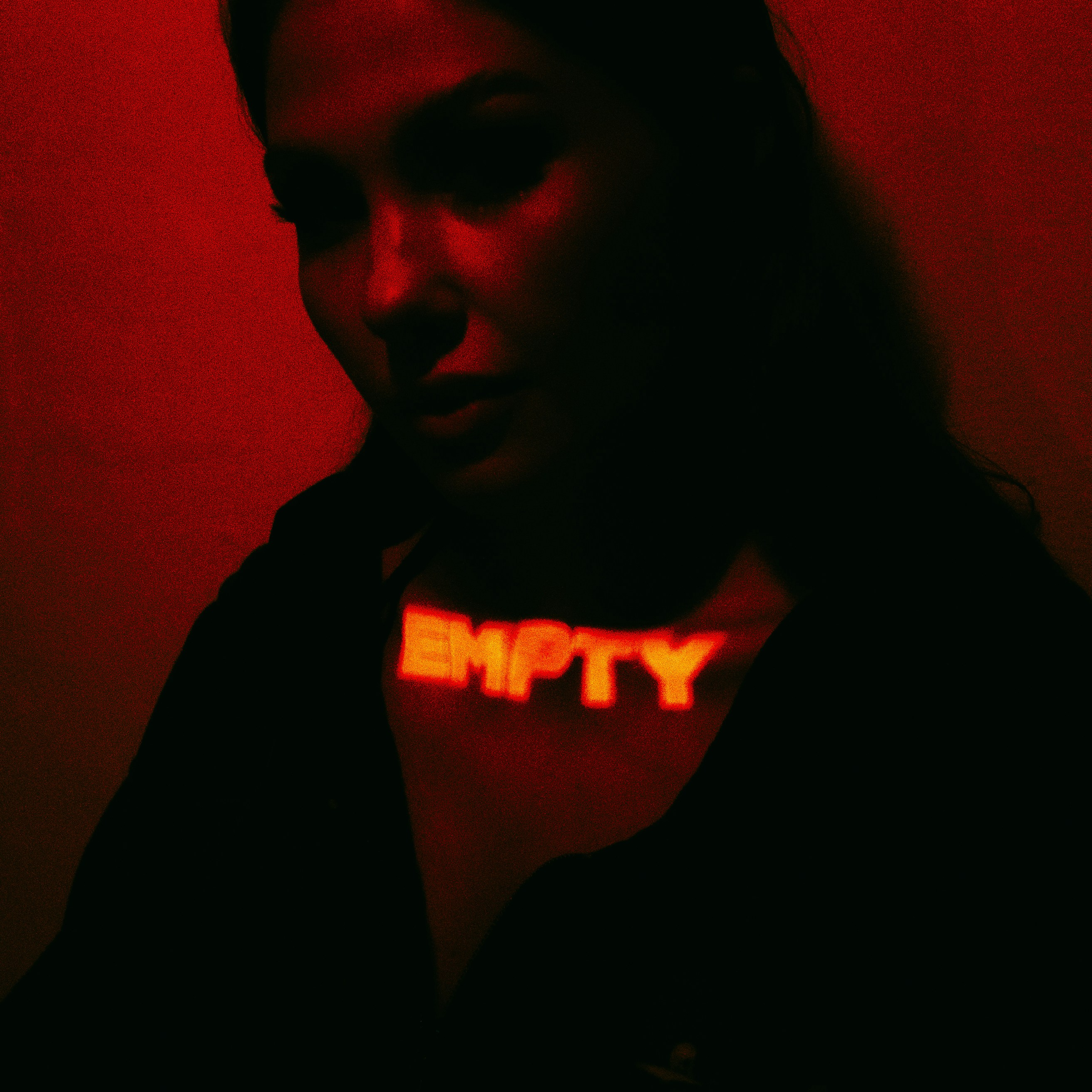 A woman in a dark room with a red light
