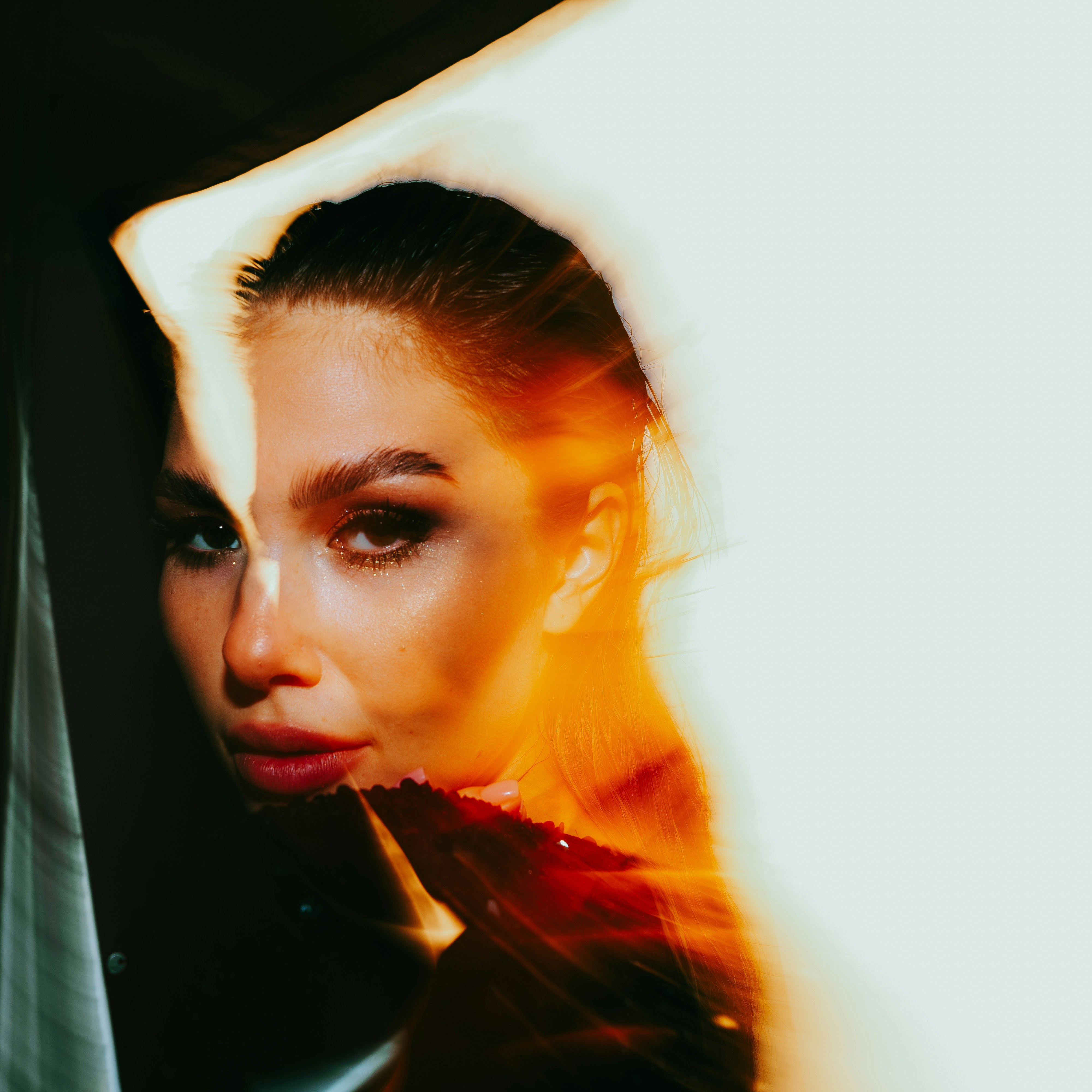 A woman in a black dress is looking at the camera