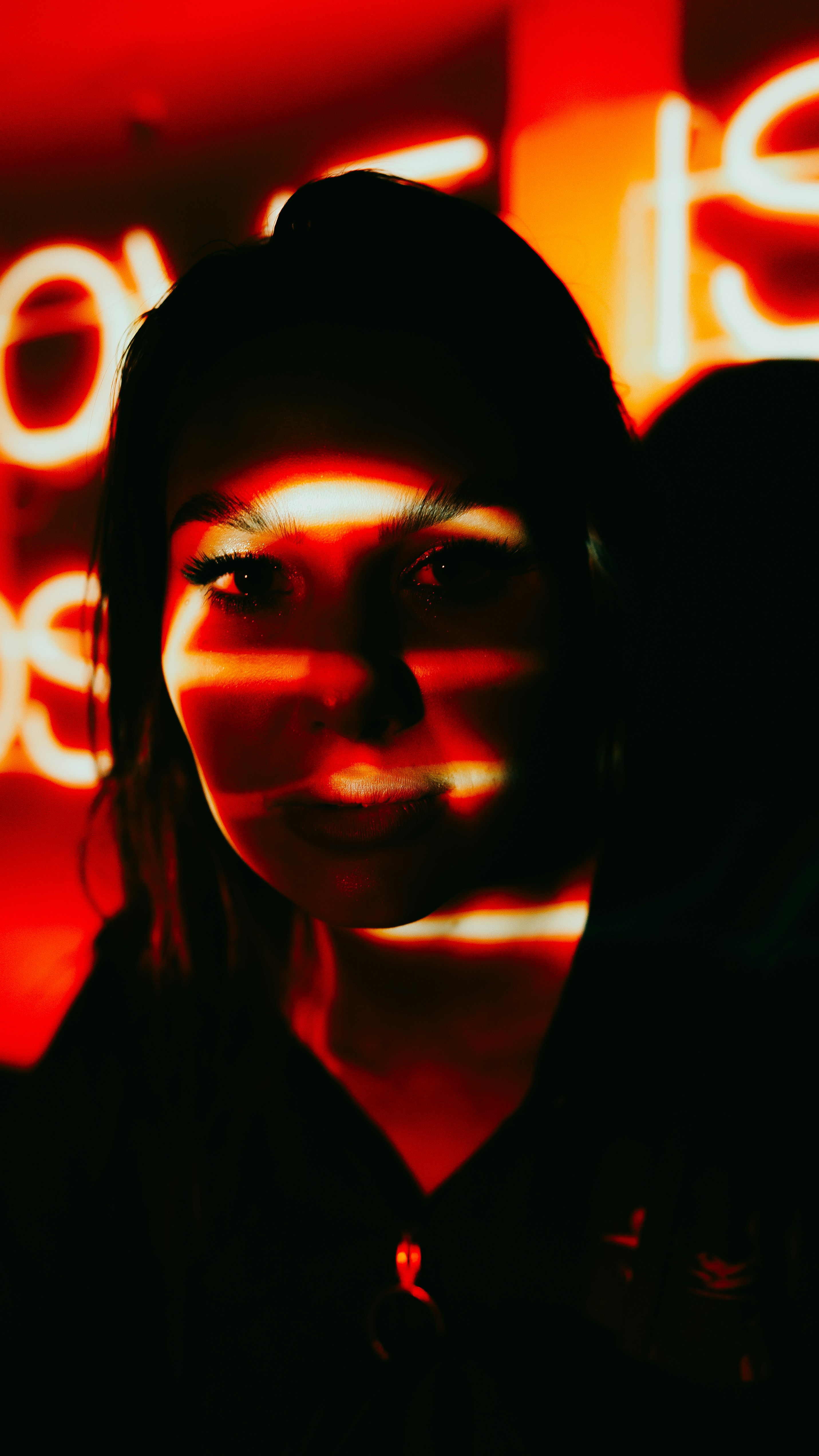 A woman standing in front of a neon sign