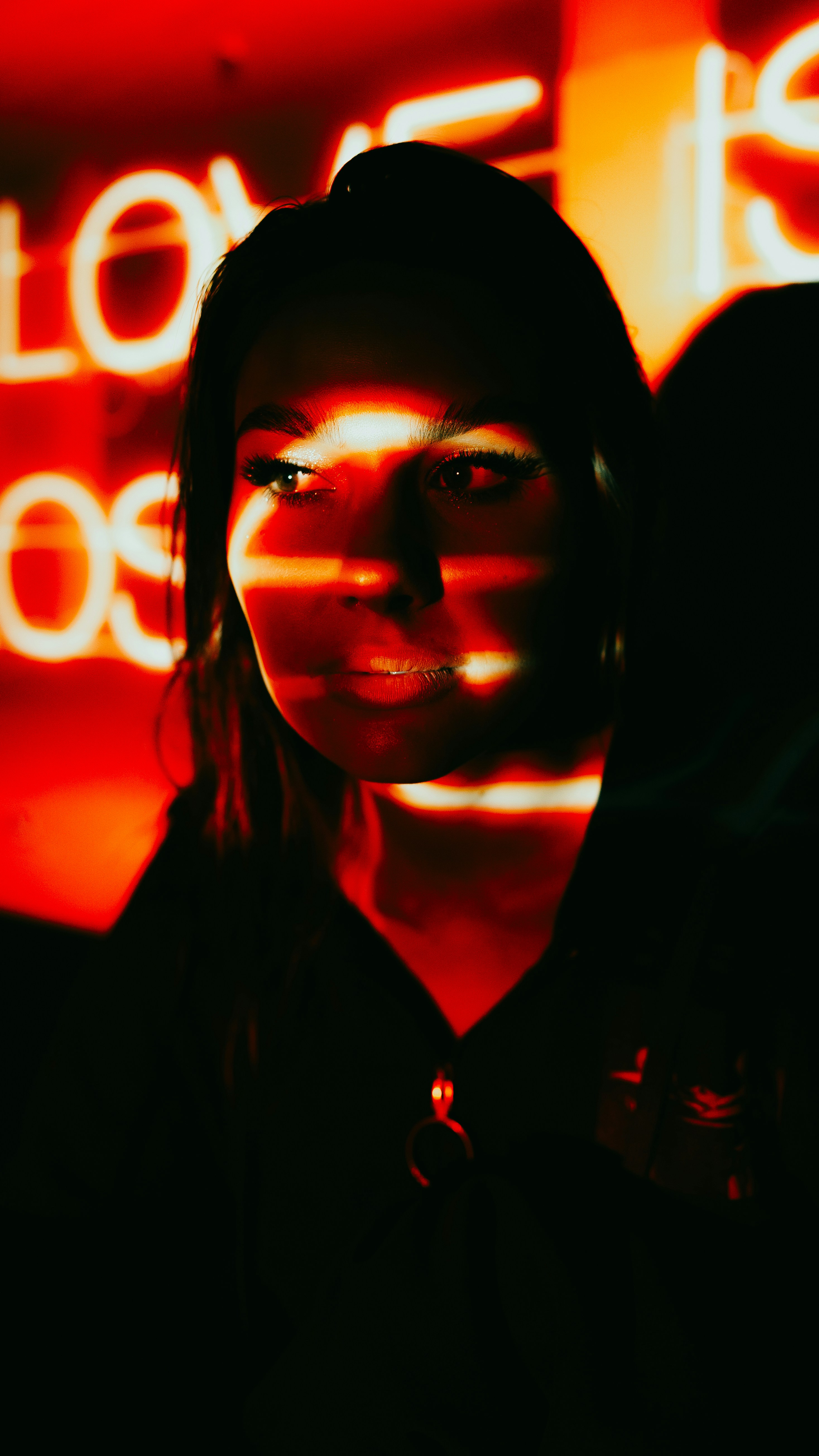 A woman standing in front of a neon sign