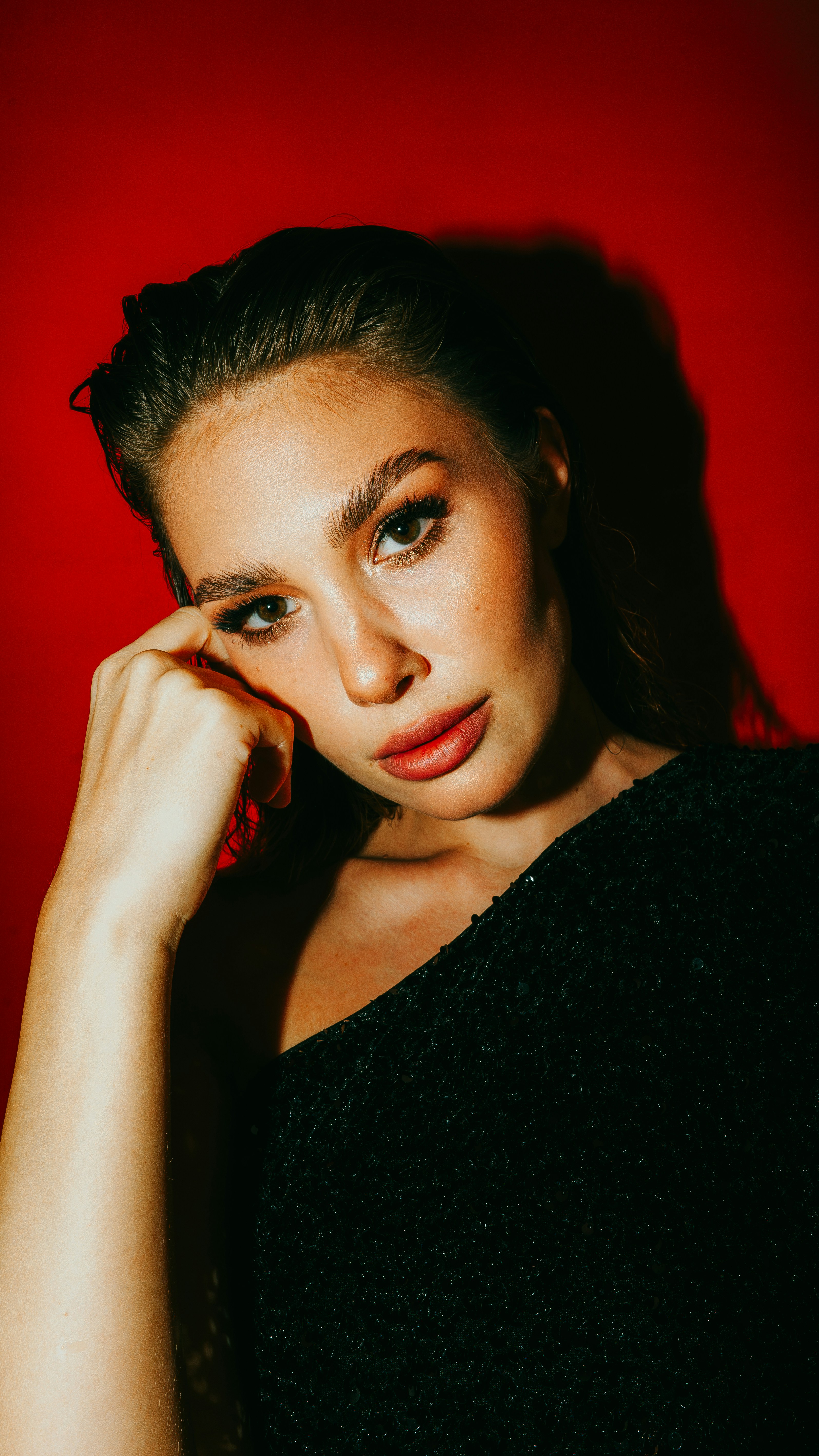 A woman posing for a picture with her hand on her head