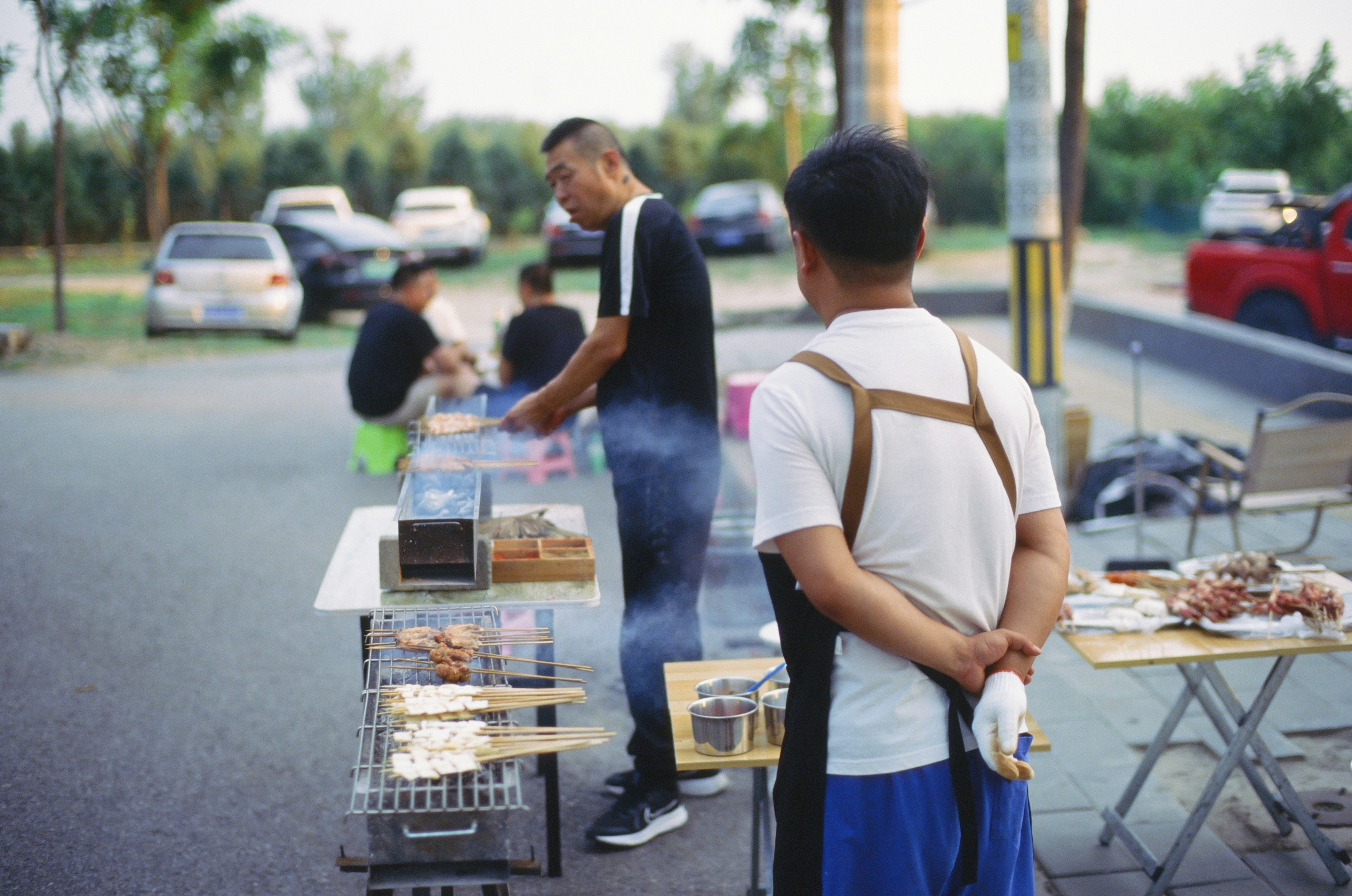A group of people standing around a table with food on it photo – Free ...