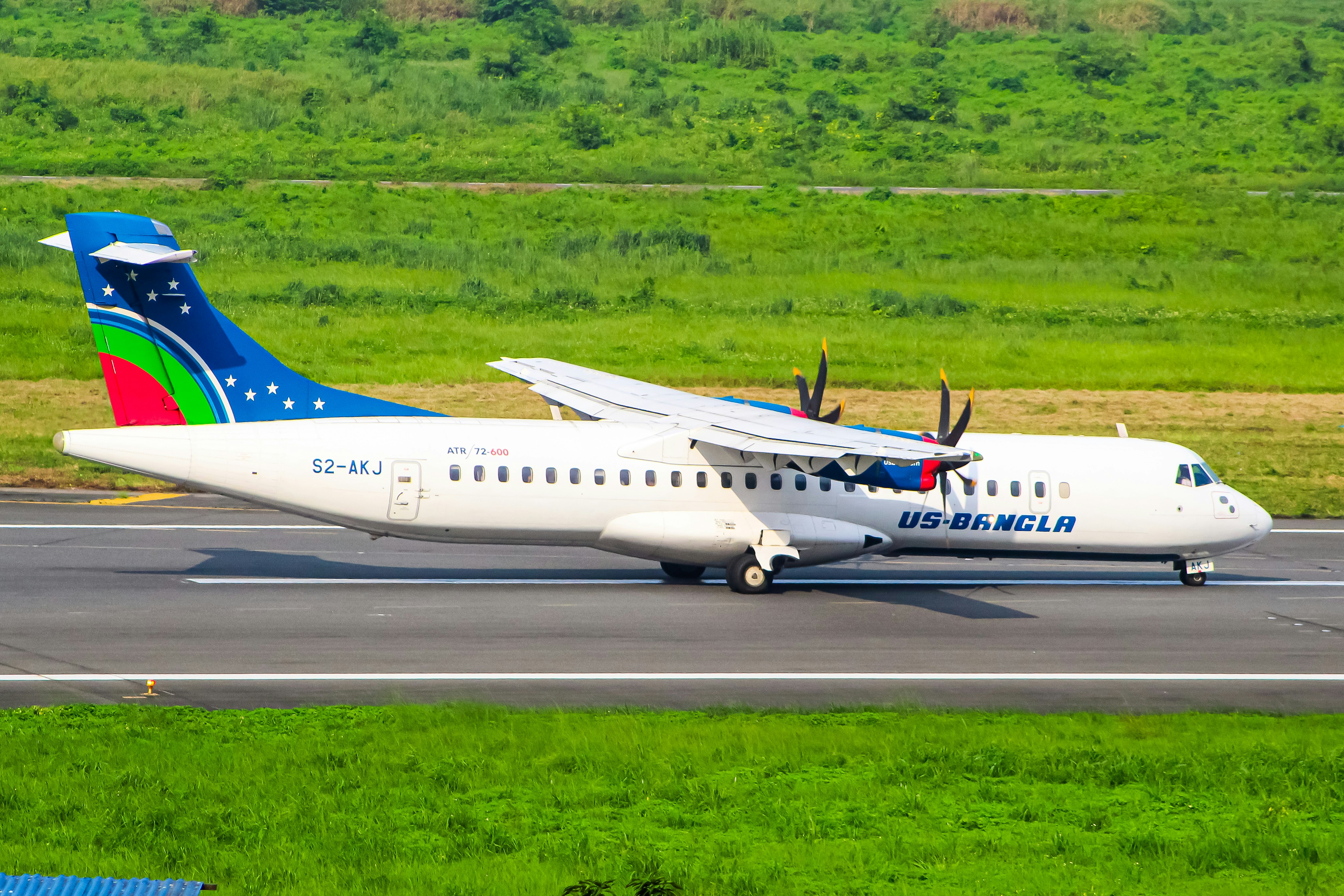 A large jetliner sitting on top of an airport runway, Us Bangla Airlines ATR 72-600